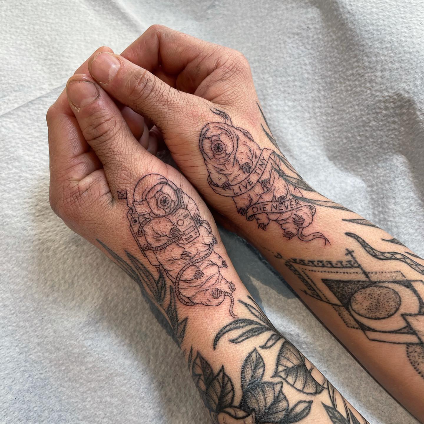 Astronauts and flowers black and grey tattoo on the forearm by @jettaturas, New City, New York