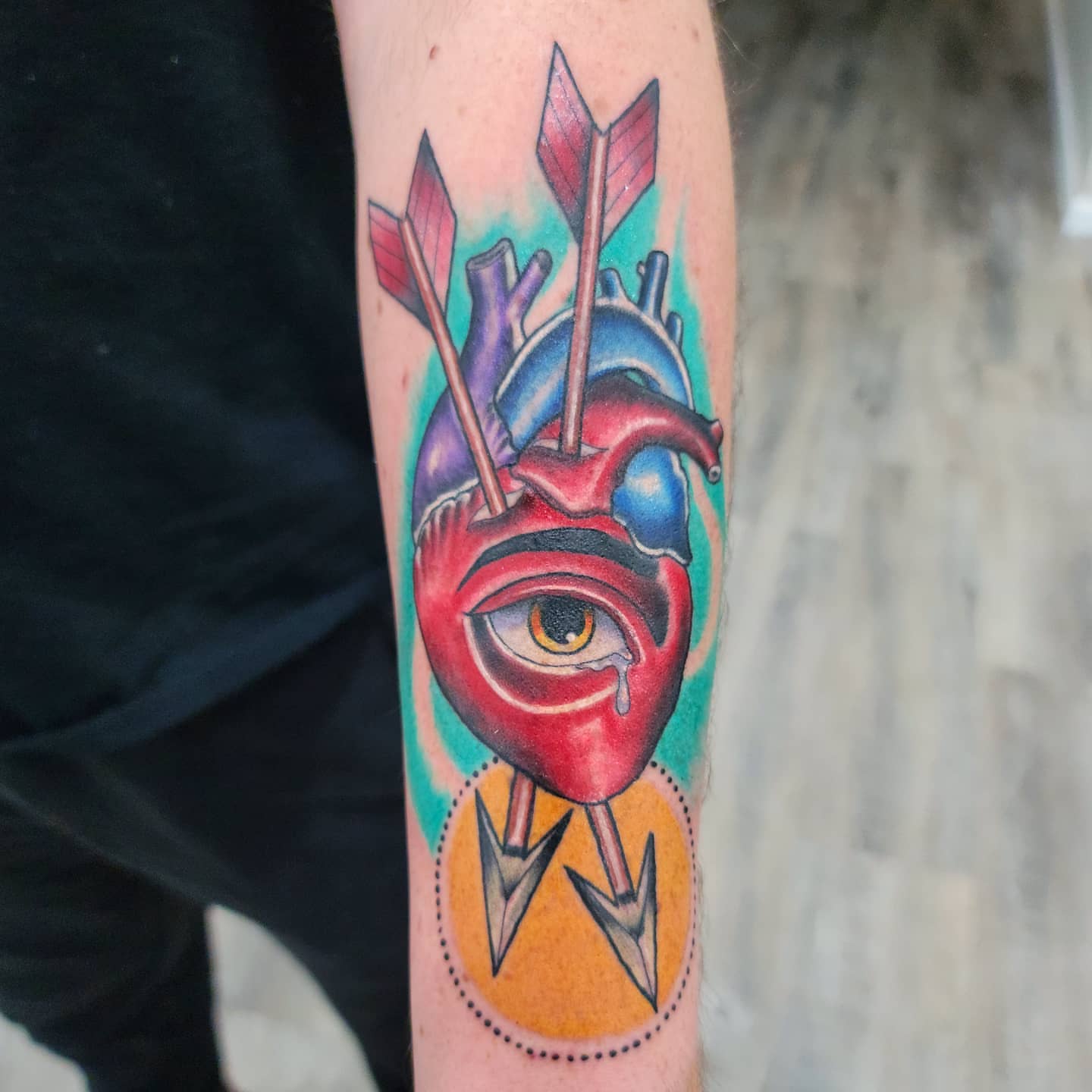 Heart with eyes American traditional tattoo on the forearm by Dick Eckman