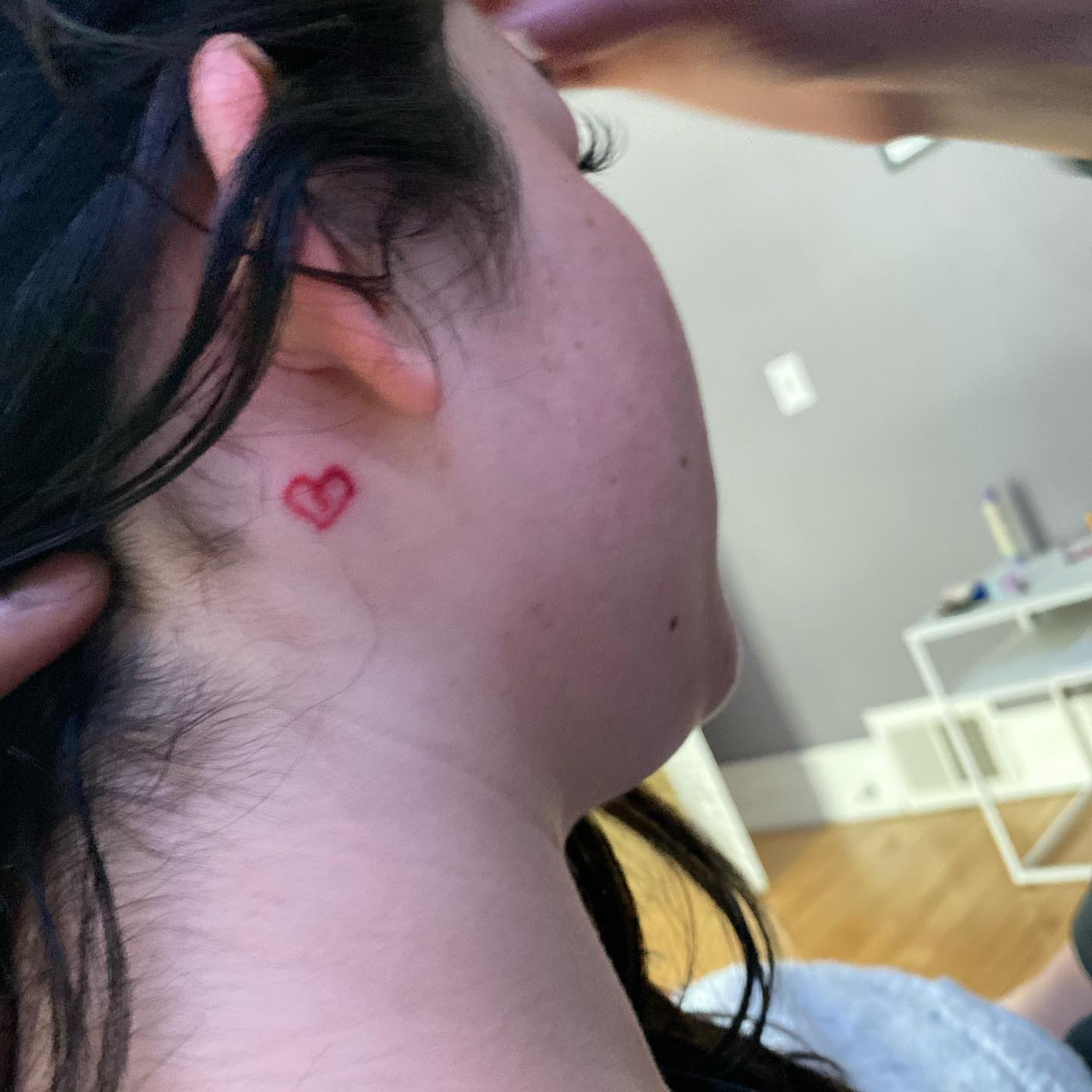 Heart fine line tattoo on the neck by Daniel Monyongo