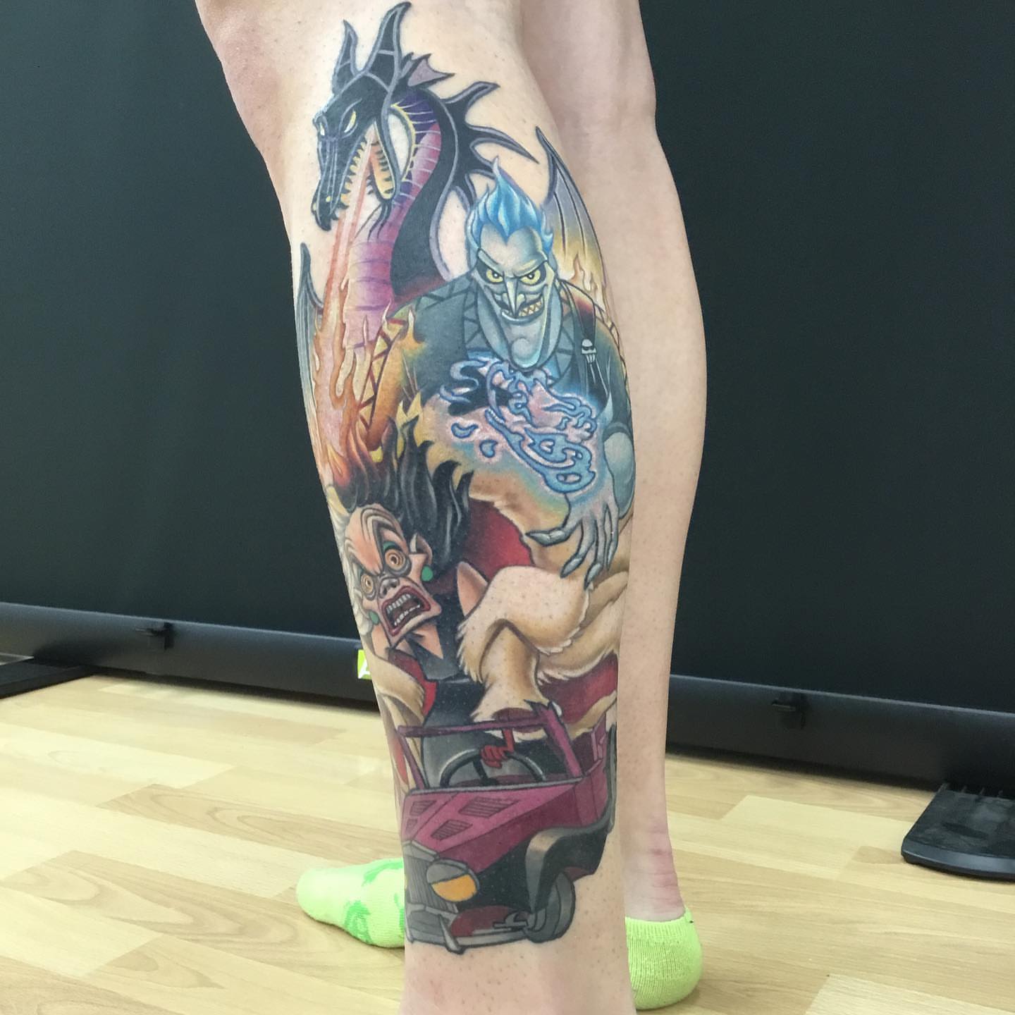 Monster truck and characters new school tattoo on the calf by Ariel Robinson