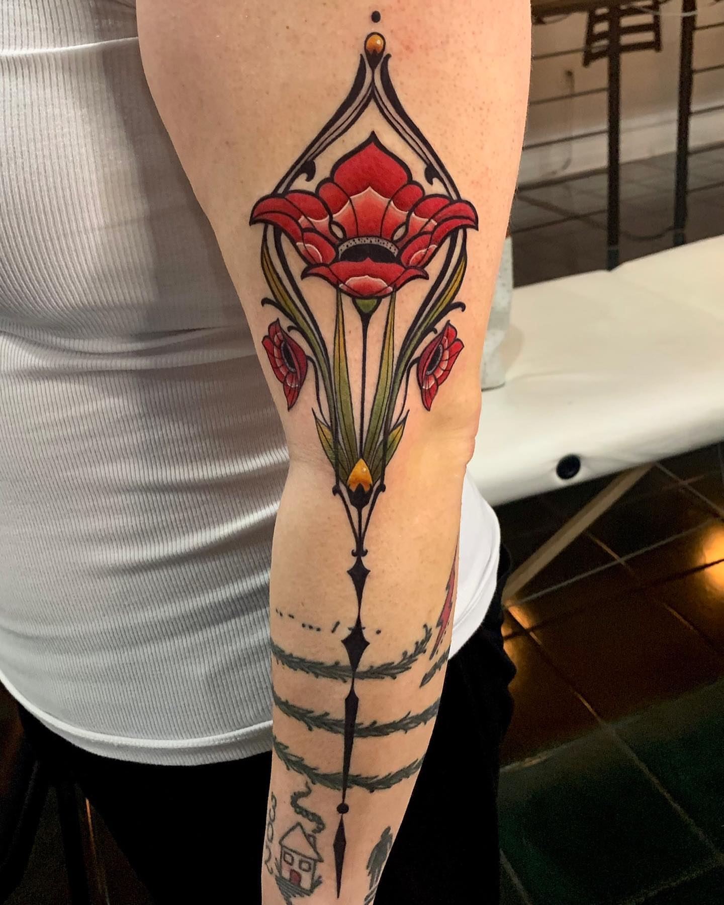 Red poppy American traditional tattoo on the forearm by Cortney Norton