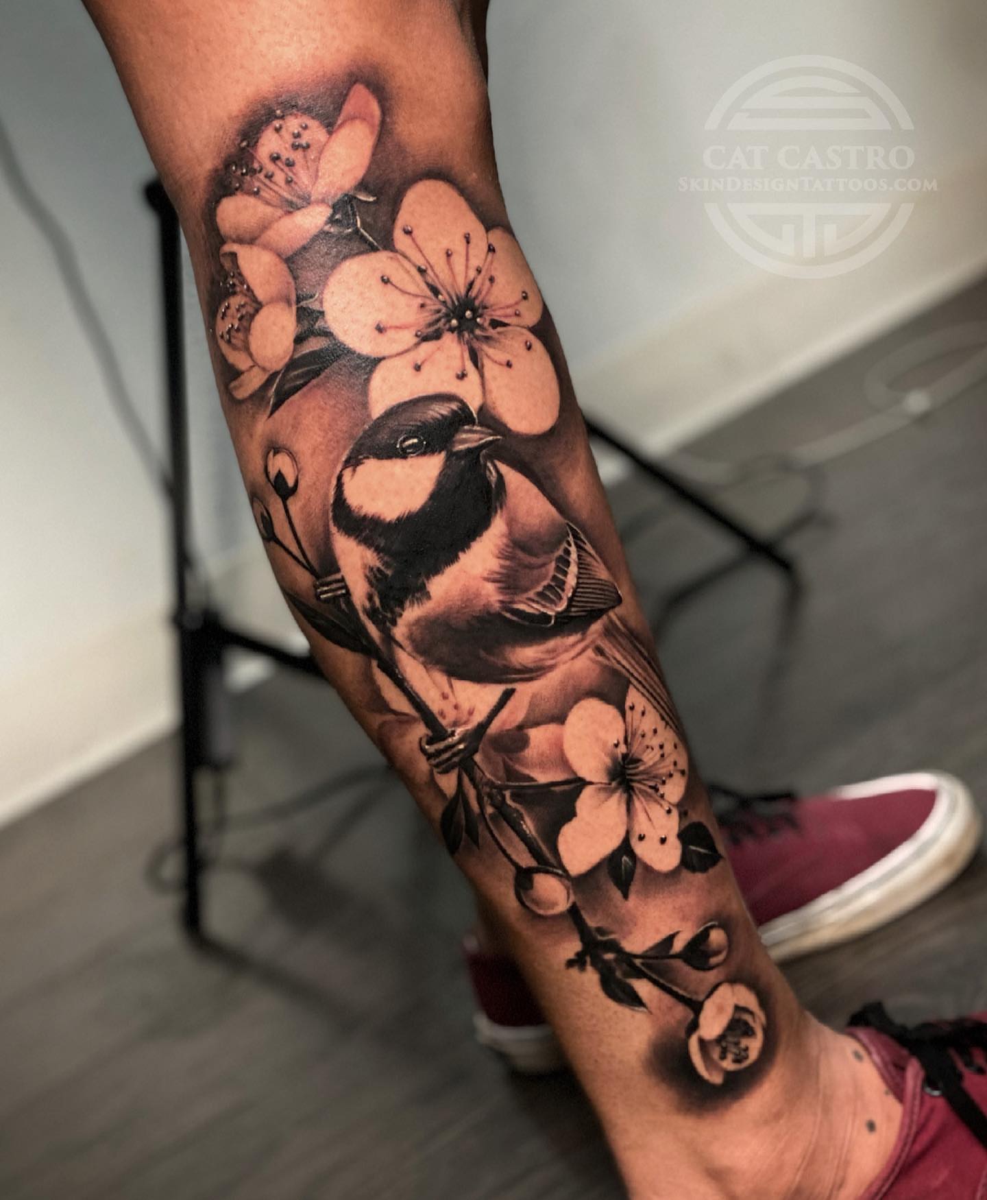 Bird and blossoms realism tattoo on the forearm by Cat Castro