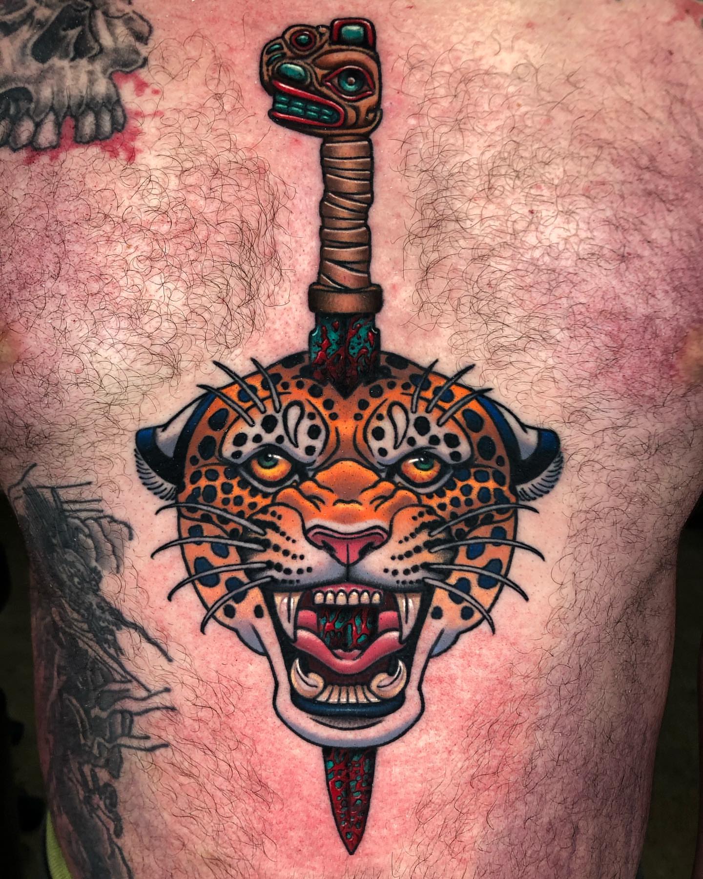Jaguar head with sword American traditional tattoo on the thigh by David Torres