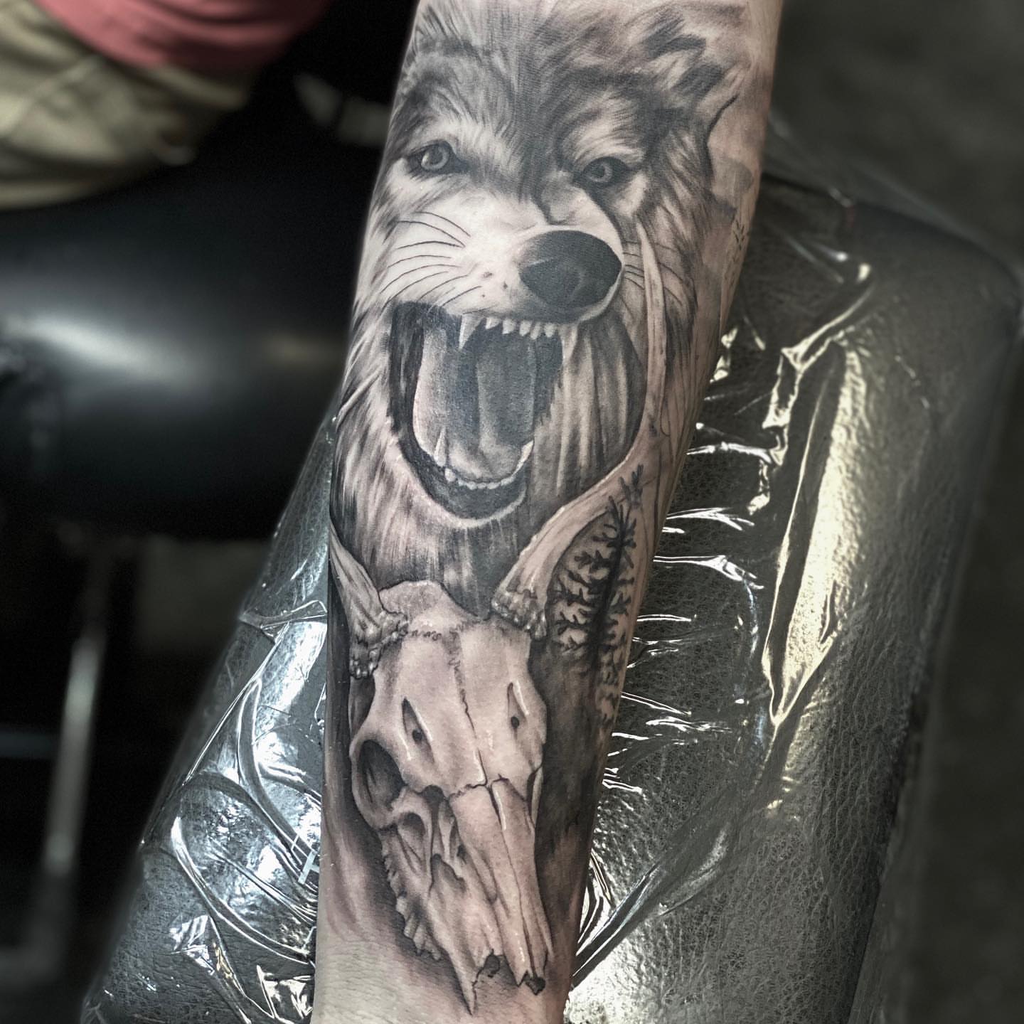 Wolf and skull realism tattoo on the forearm by Aaron Watson