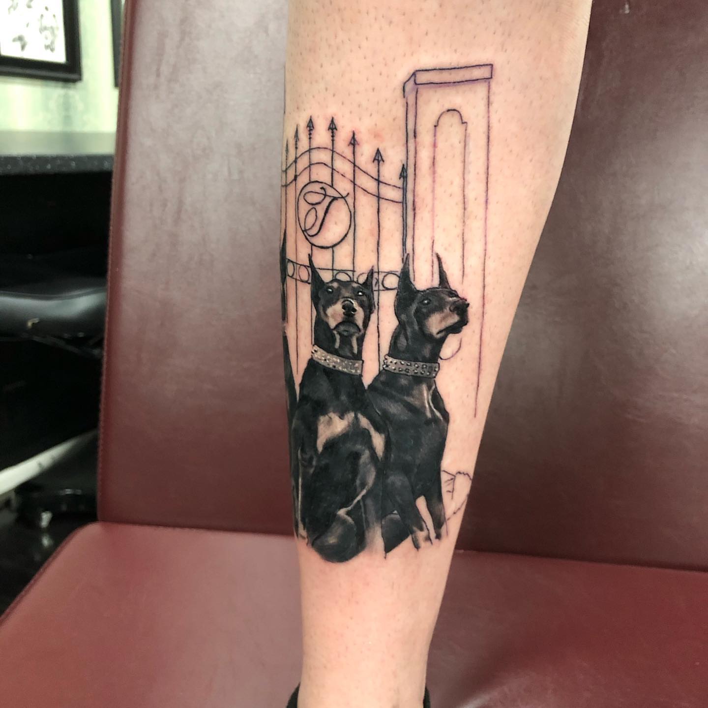 Doberman dogs black and grey tattoo on the forearm by Tattoos by Rey G.