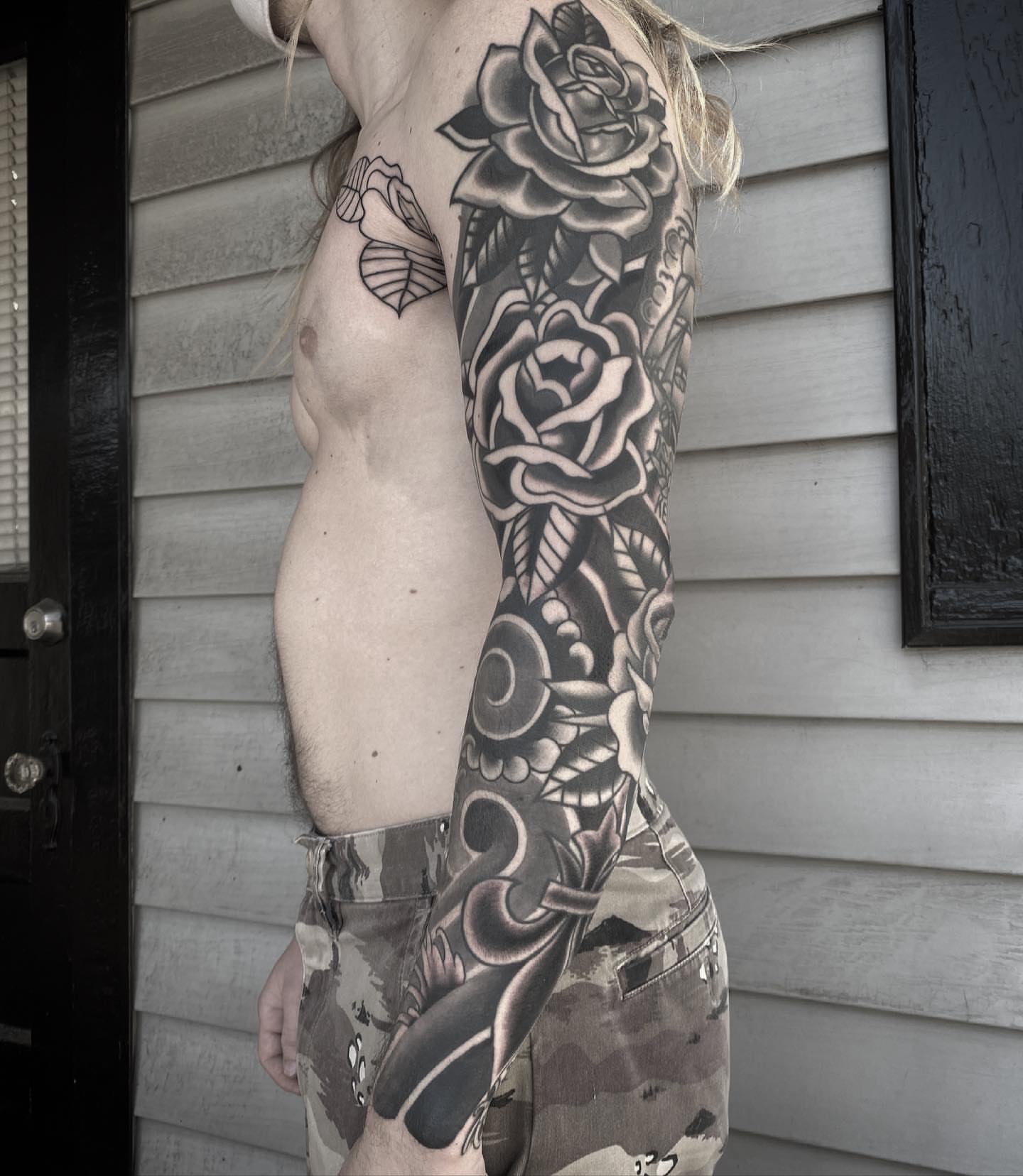 Roses and skull realism tattoo on the upper arm by Daniel Mesen
