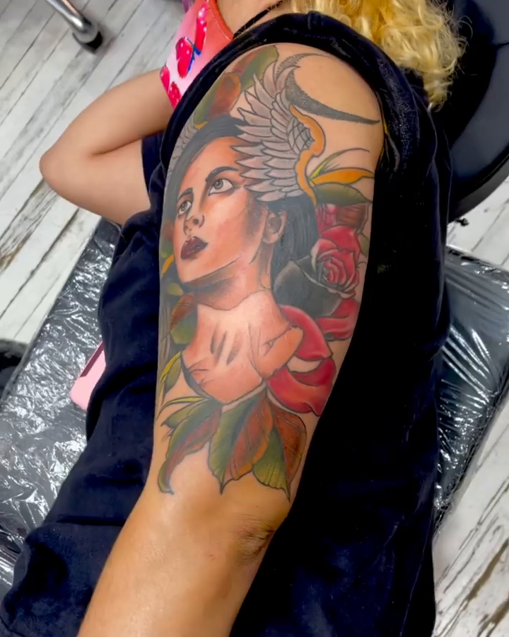 Woman with wings and roses realism tattoo by E