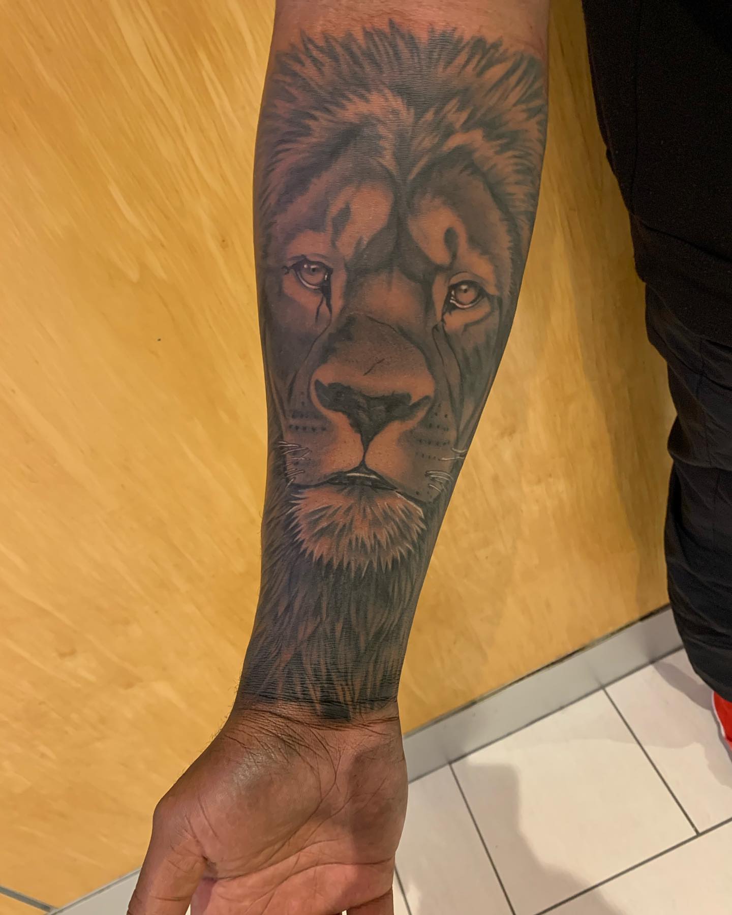 Lion realism tattoo on the forearm by ATLANTA Queer Tattooer