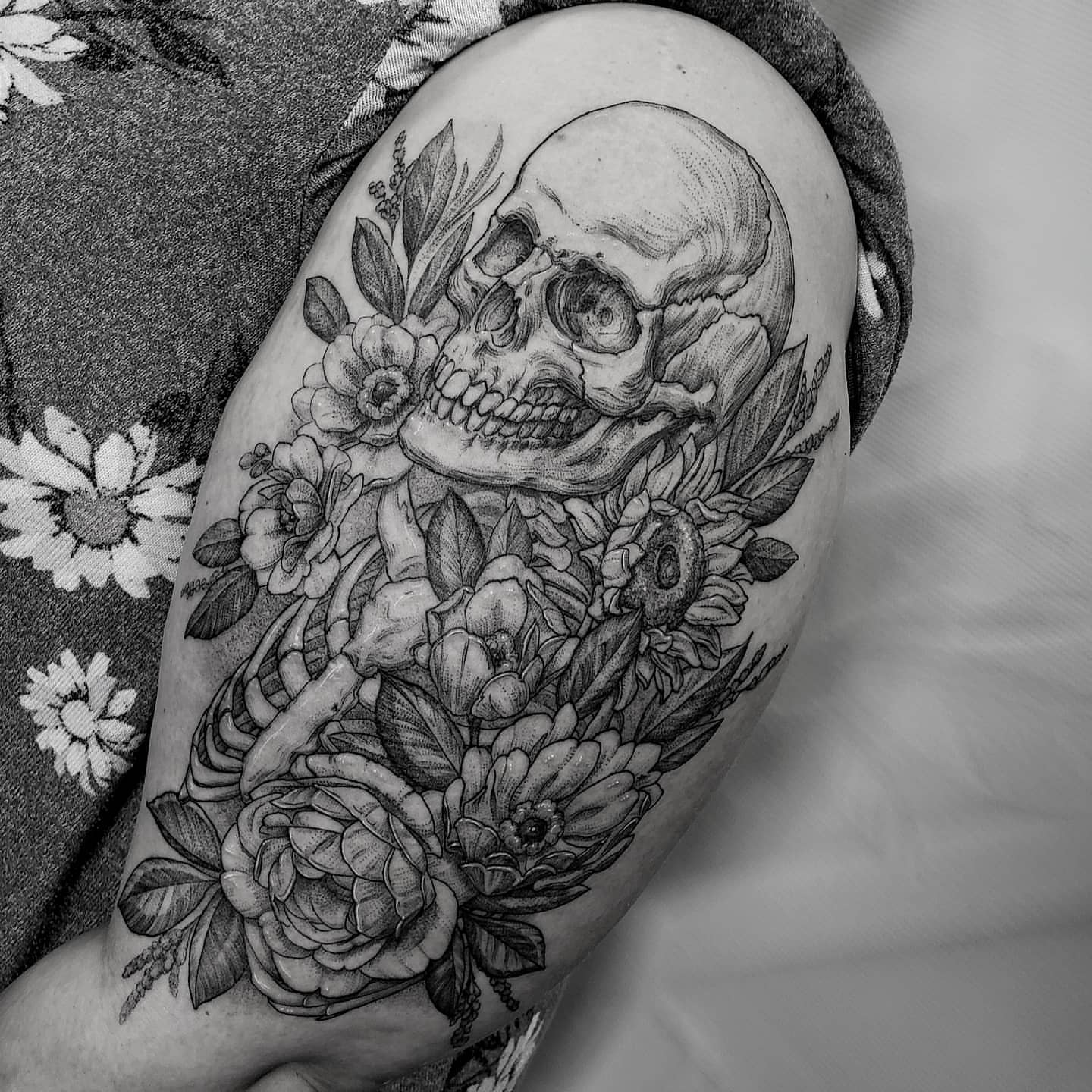 Skull and floral arrangement realism tattoo on the upper arm by Matthew Barnett