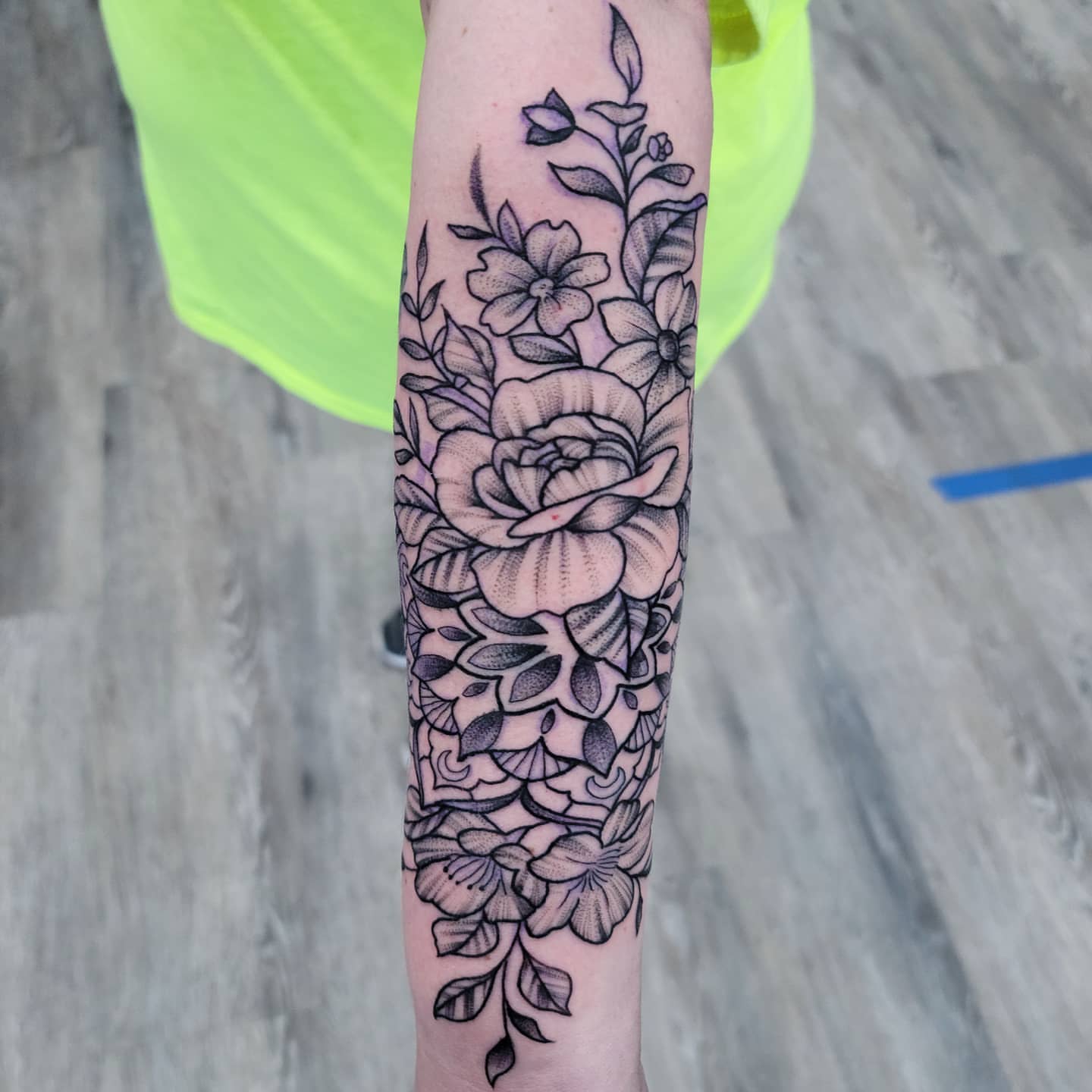Floral arrangement black and grey tattoo on the forearm by Dick Eckman