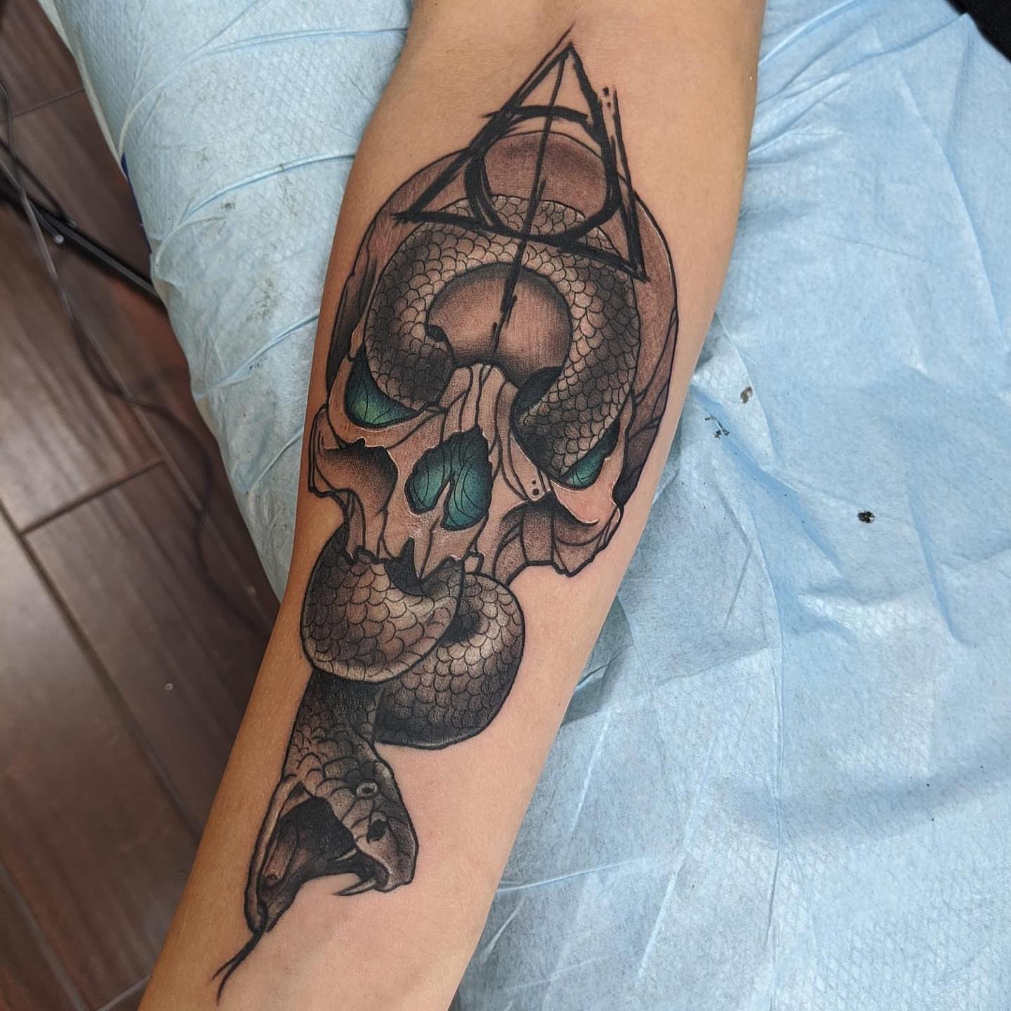 Skull with snake geometric tattoo on the forearm by Seth Scott