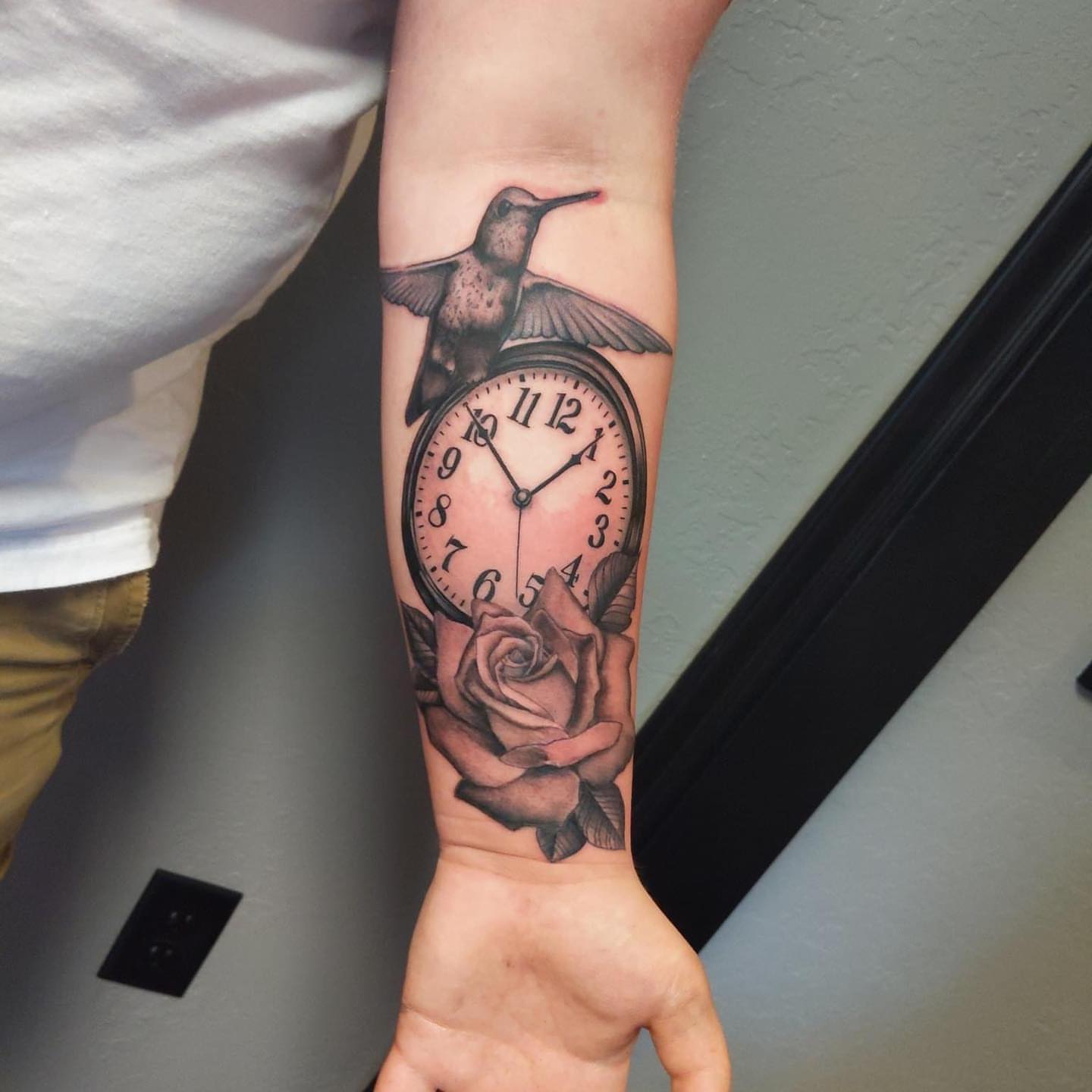 Clock with hummingbird and rose realism tattoo on the forearm by Seth Scott