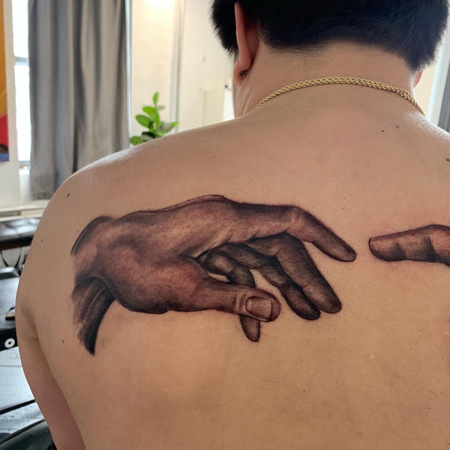 Hands realism tattoo on the back by Anthony Macias