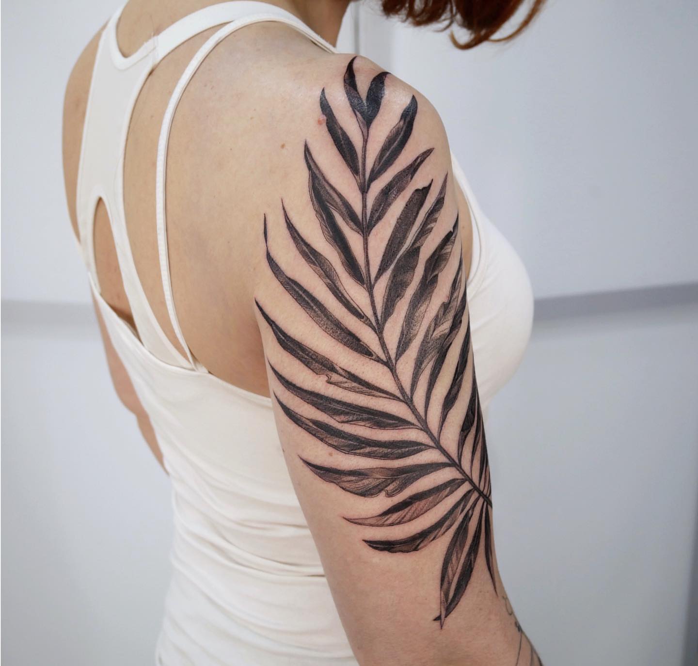 Fern leaf black and grey tattoo on the upper arm by Tattoo San Diego