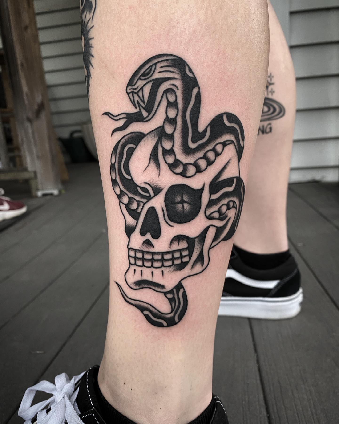 Skull and snake black and grey tattoo on the forearm by Daniel Mesen