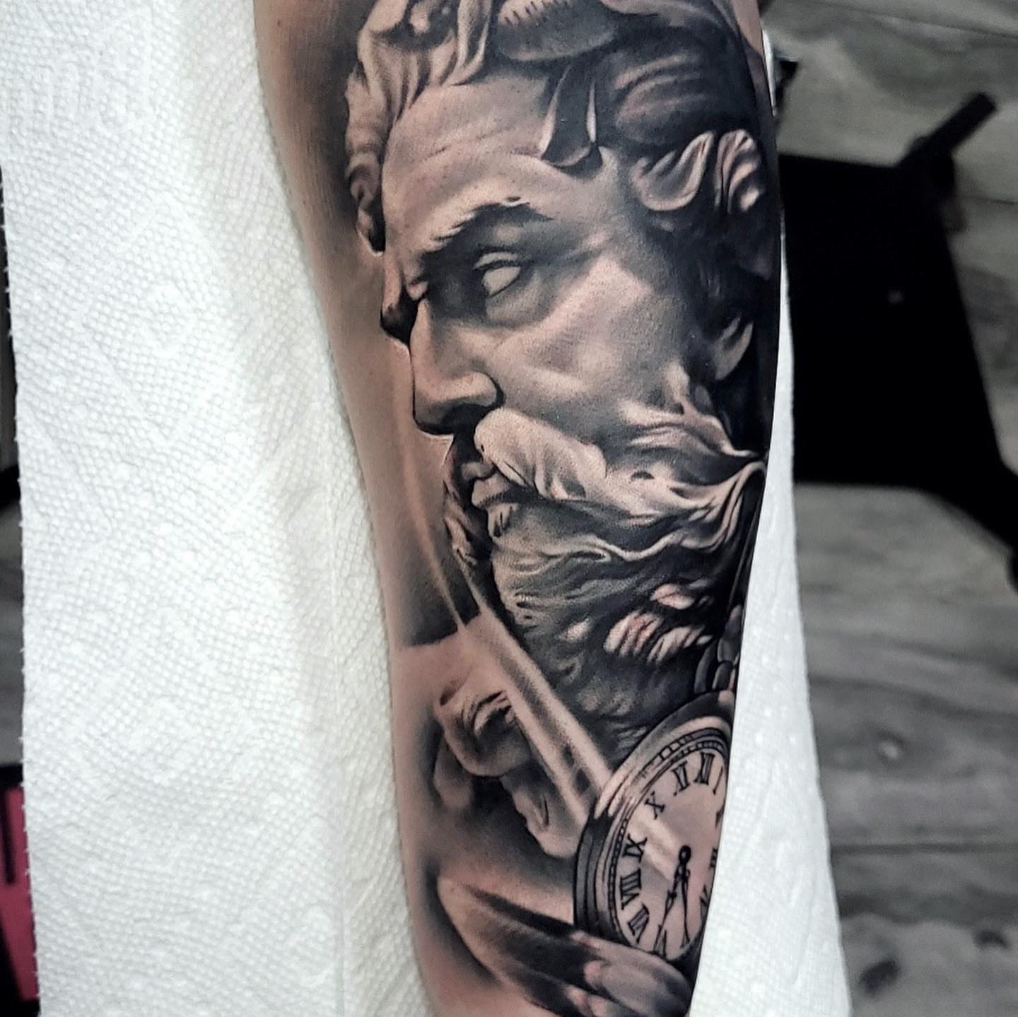 Statue head with pocket watch realism tattoo on the forearm by Angel Perez
