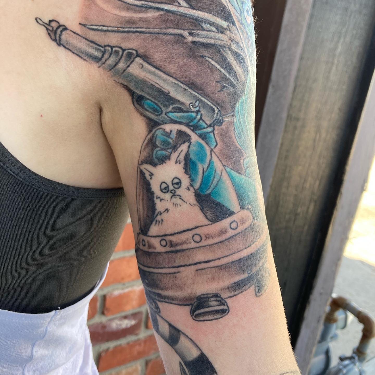 Cat in space helmet realism tattoo on the forearm by Chuck House