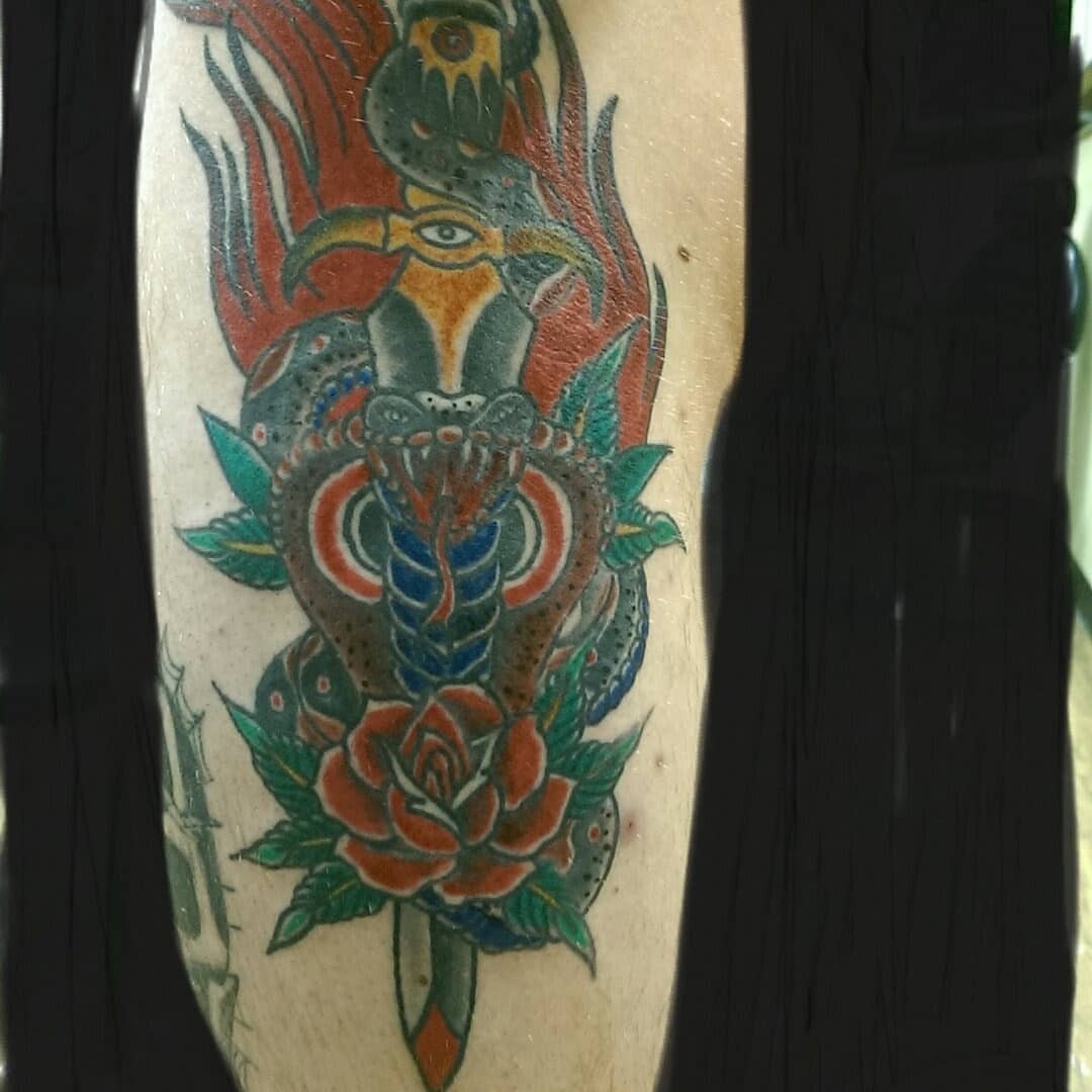 Snake and rose American traditional tattoo on the forearm by Rue McLean
