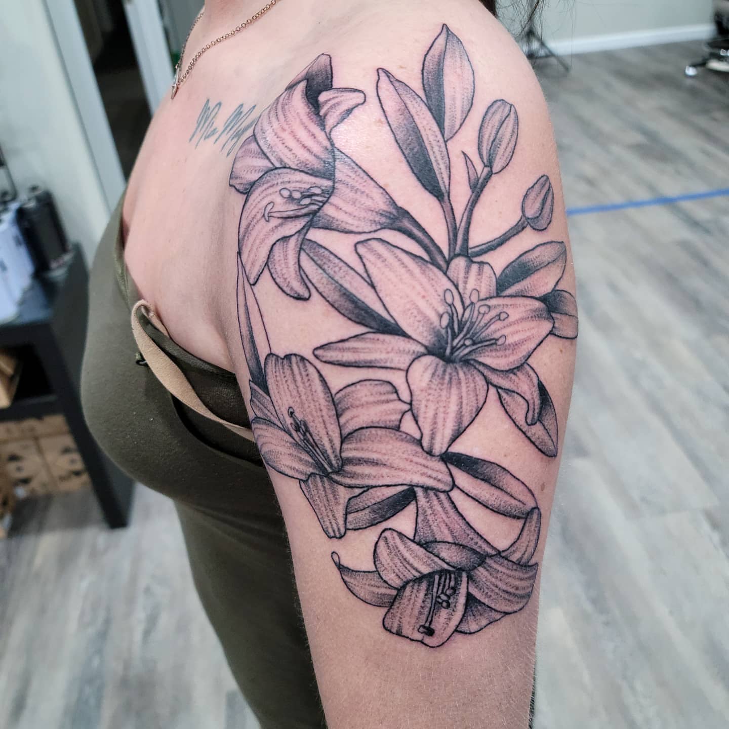 Lilies dotwork tattoo on the shoulder by Dick Eckman