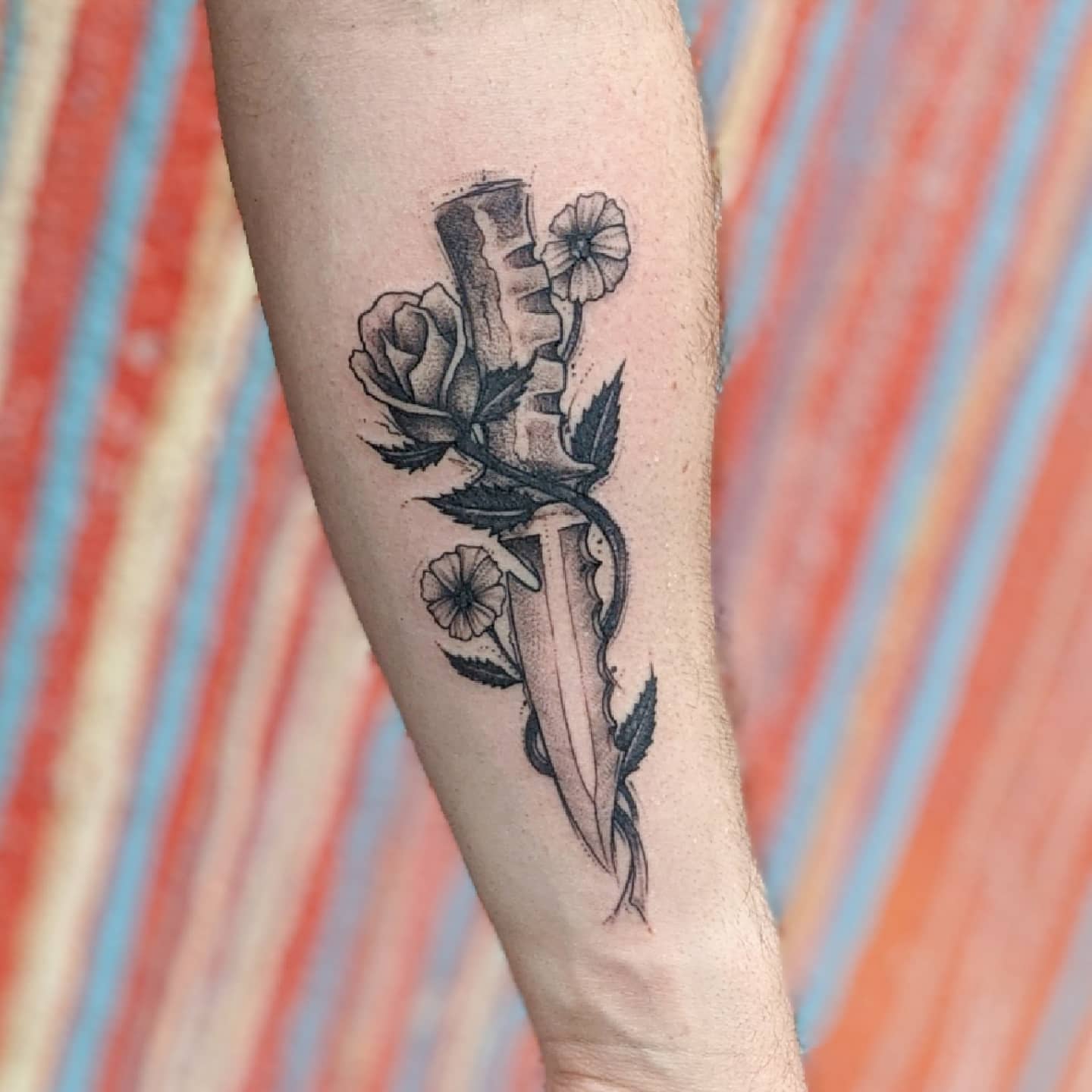 Knife and roses black and grey tattoo on the forearm by Gail Howard Perry III