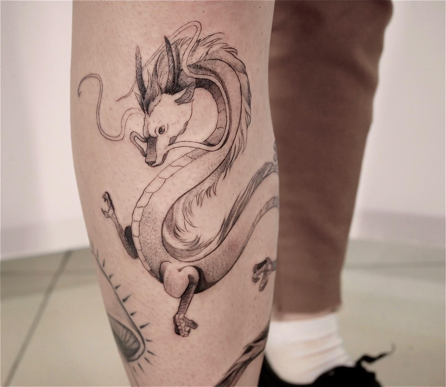 Dragon black and grey tattoo on the calf by Tattoo San Diego