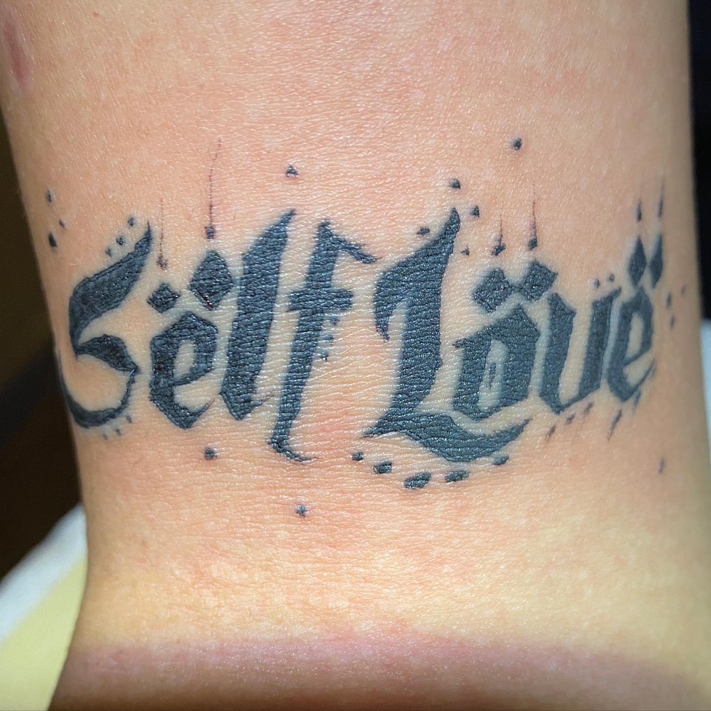 Self Love lettering script tattoo on the forearm by Nick