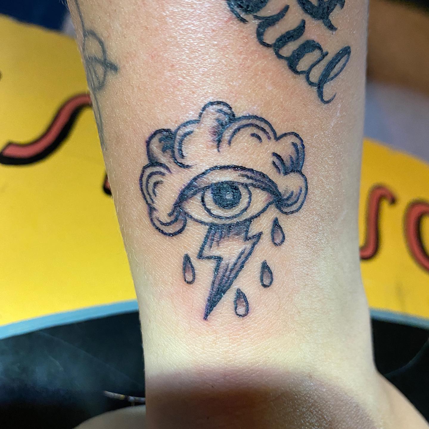 Eye with cloud and lightning neo-traditional tattoo on the forearm by Nick
