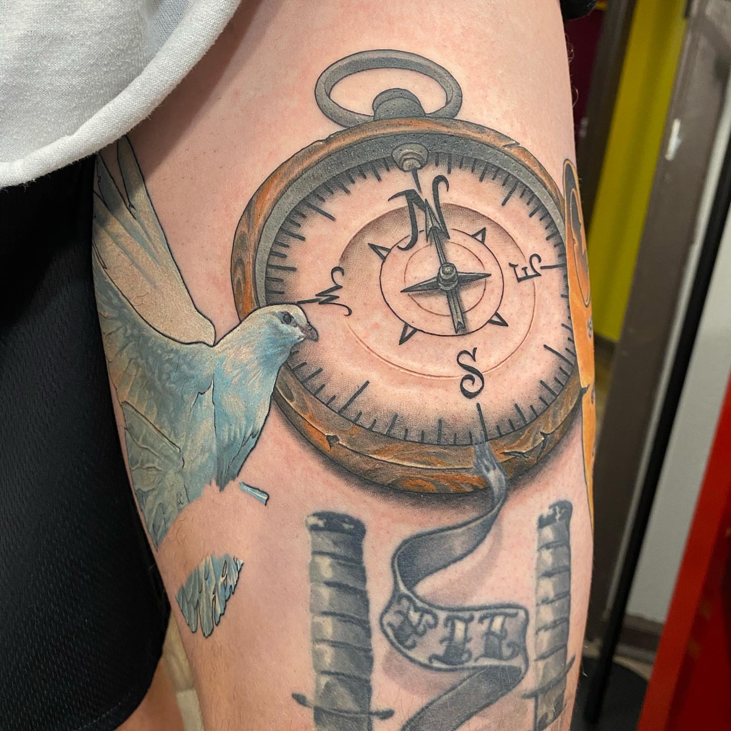 Compass and bird realism tattoo on the forearm by Dustin Lane Collins