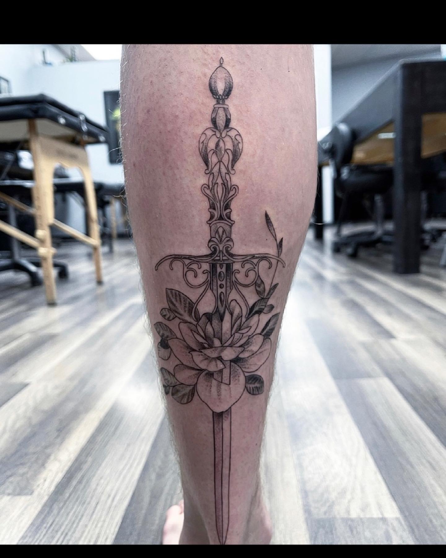 Sword and flower ornamental tattoo on the calf by Beans