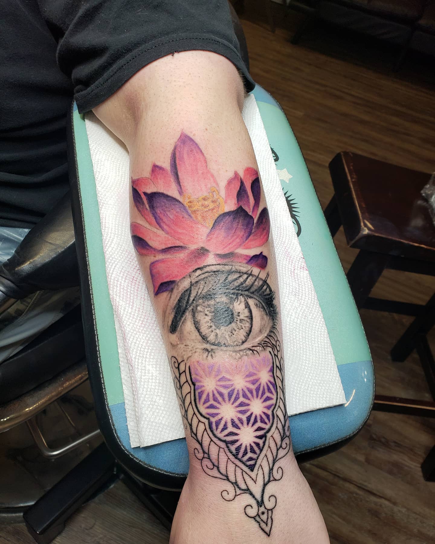 Lotus flower and eye watercolor tattoo on the forearm by Kayla Linton