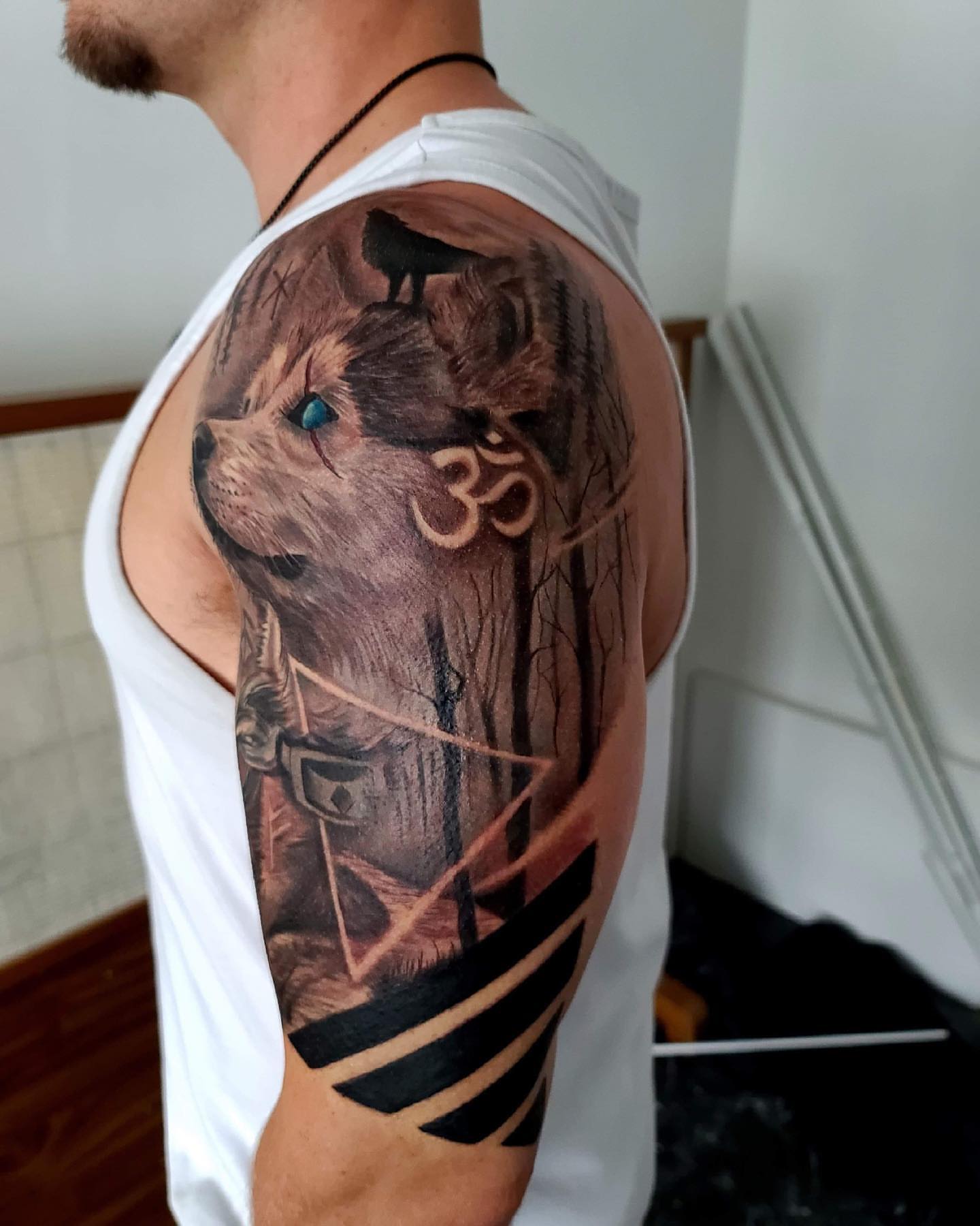 Dog with bird realism tattoo on the upper arm by Levi Tattoo Artist, Utah