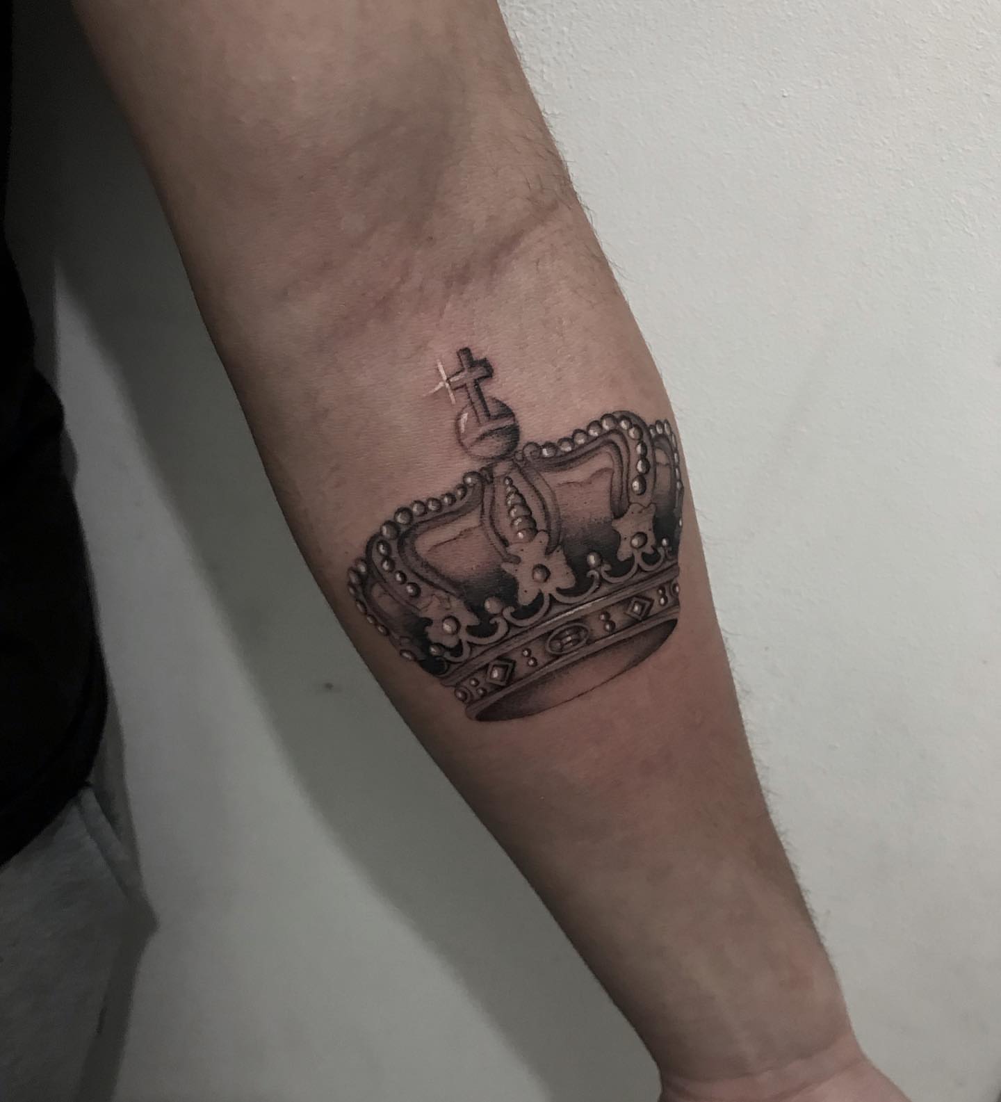 Crown black and grey tattoo on the forearm by Diego Aravena