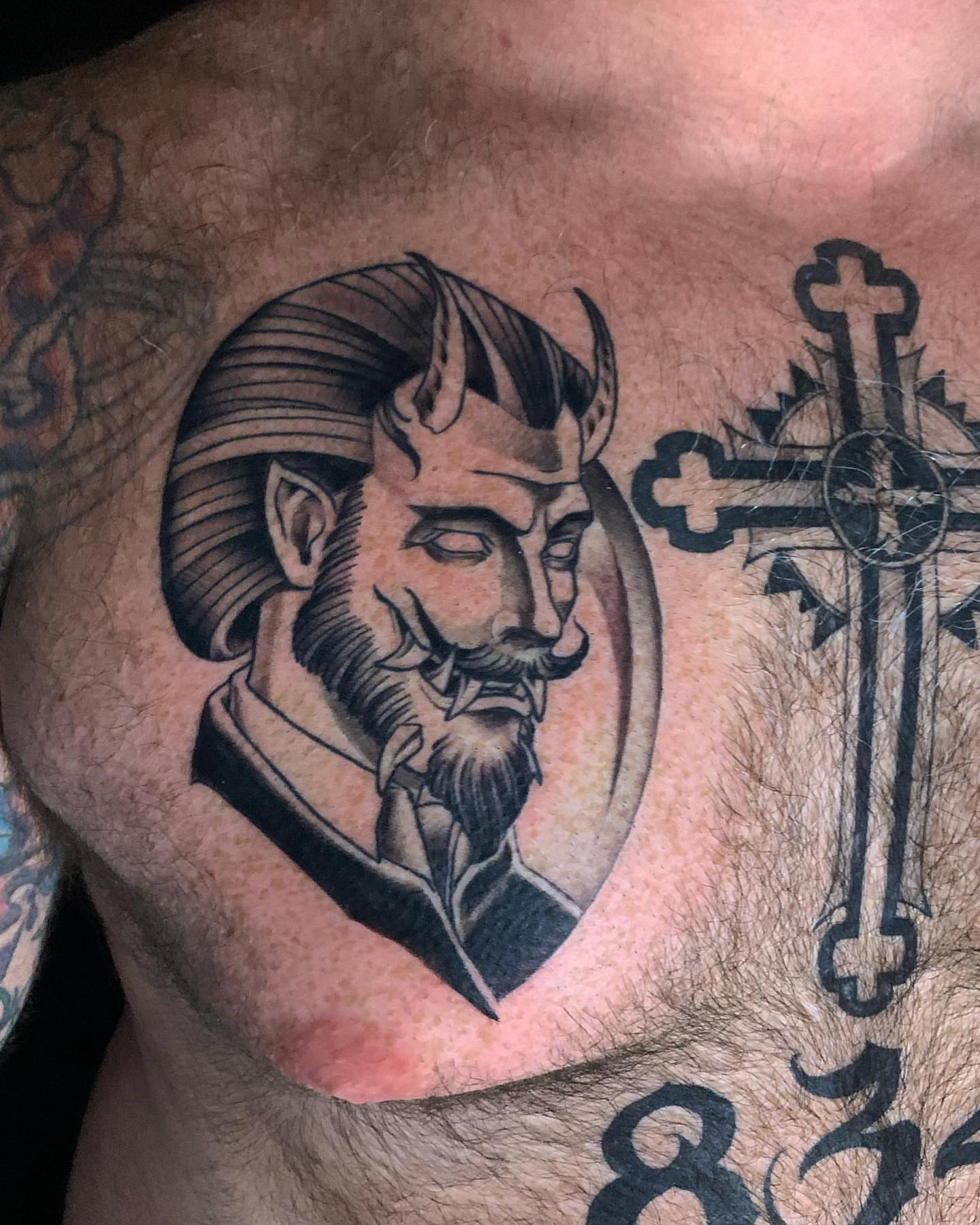 Man's head black and grey tattoo on the chest by Neo-Traditional tattoos in Las Vegas