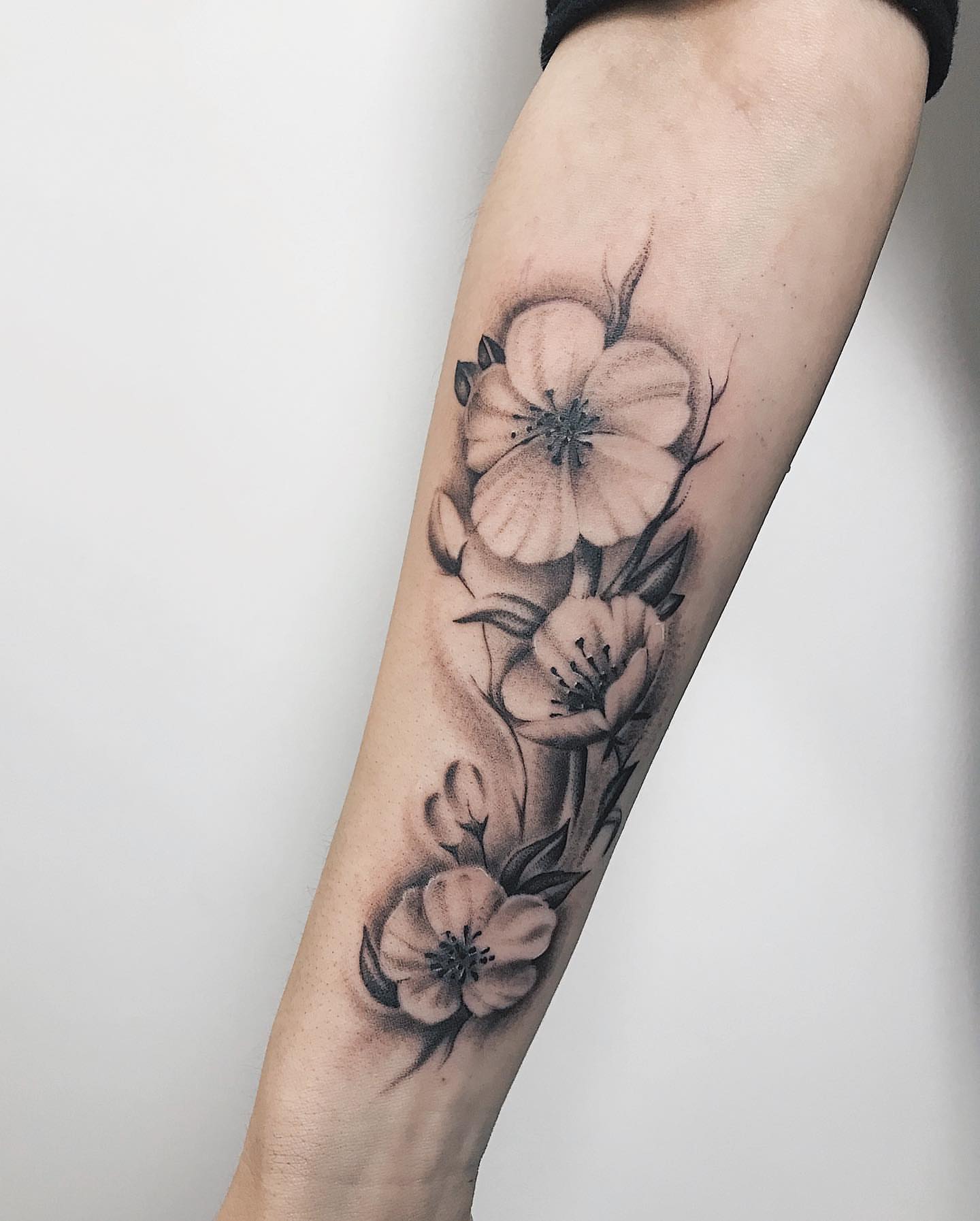 Flowers black and grey tattoo on the forearm by Annie Overchuk