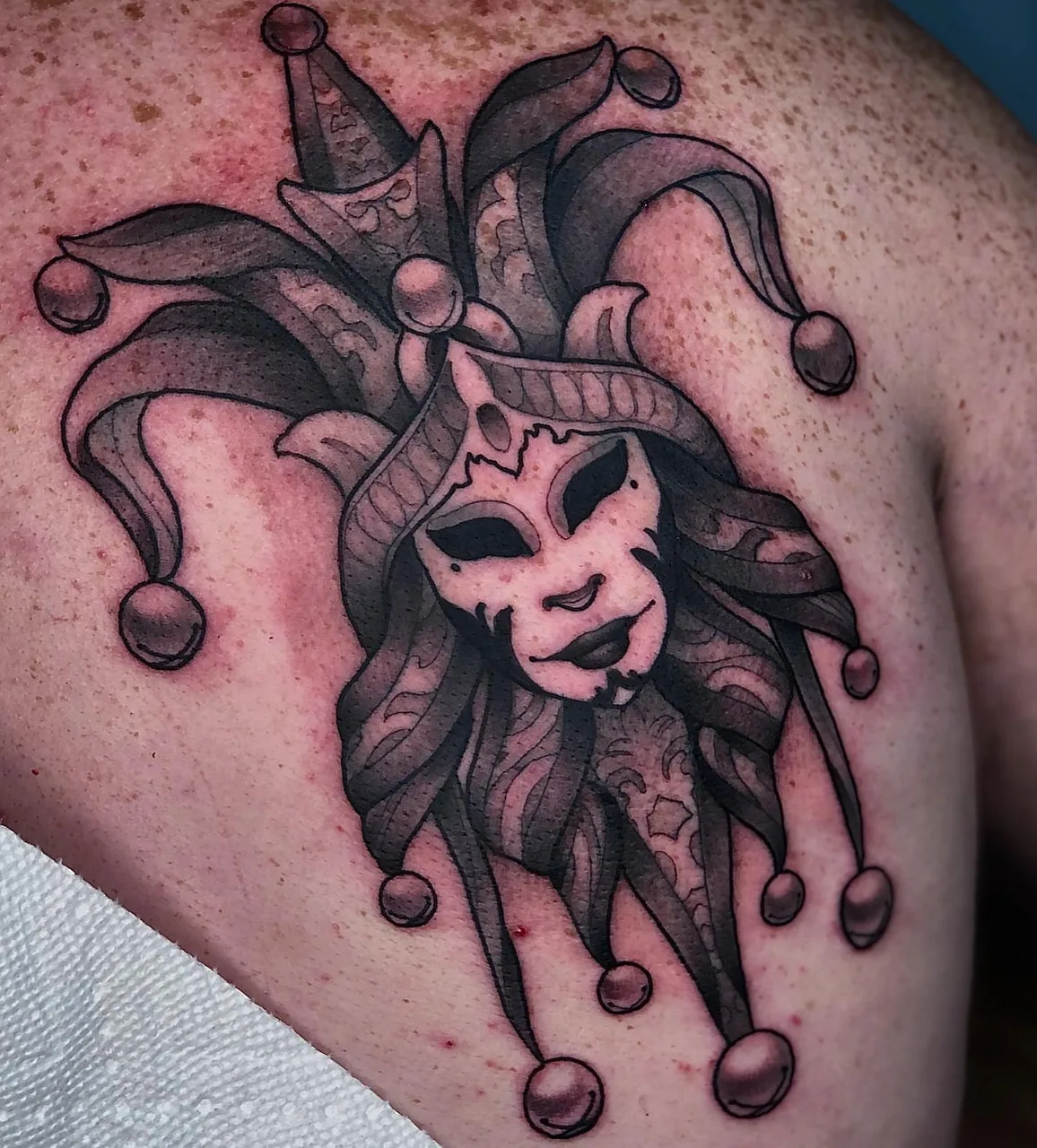 Jester mask black and grey tattoo on the shoulder by ✤ ᴋɪʀᴀ ᴋɴᴏᴡʟᴛᴏɴ ✤