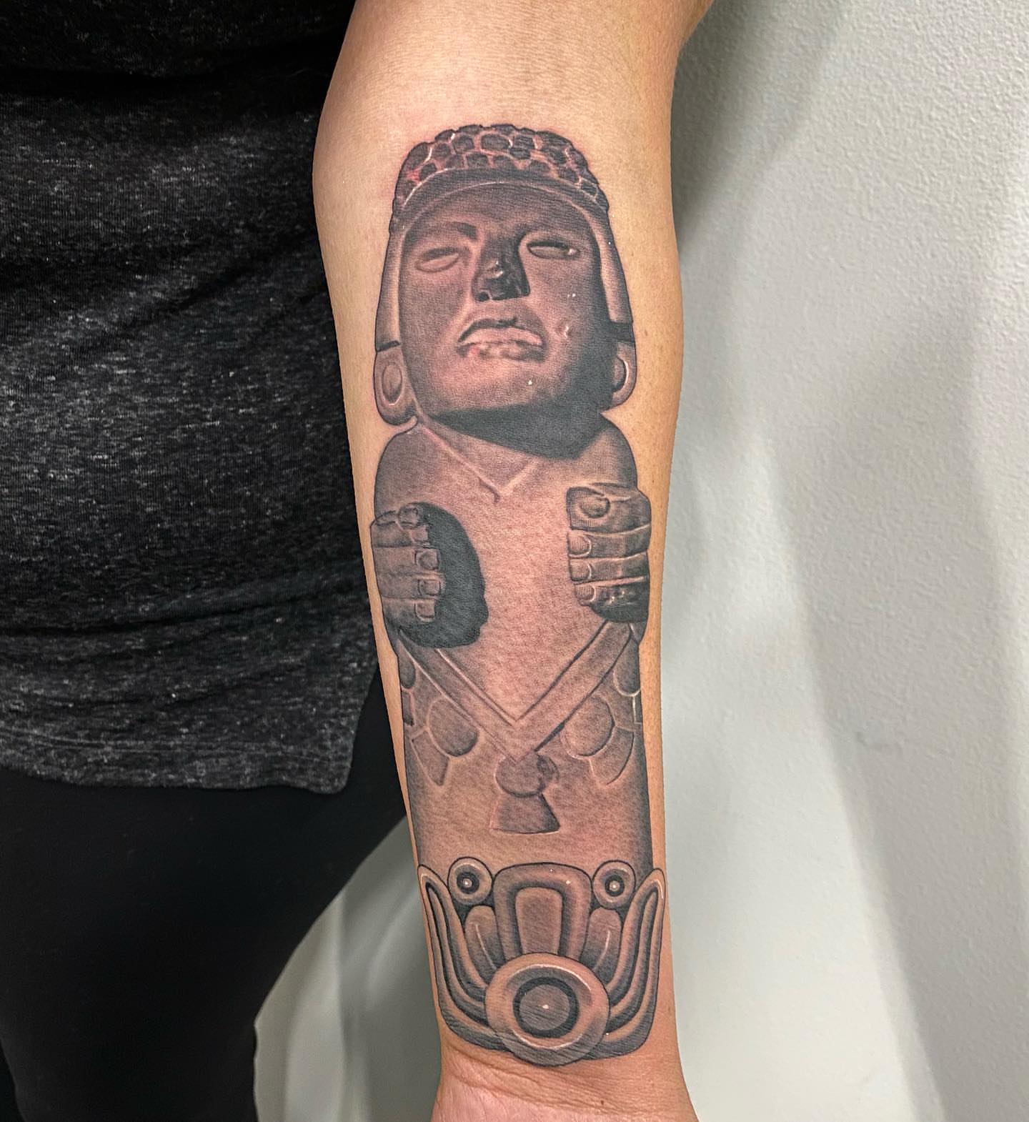 Ancient statue black and grey tattoo on the forearm by Junior Nunez