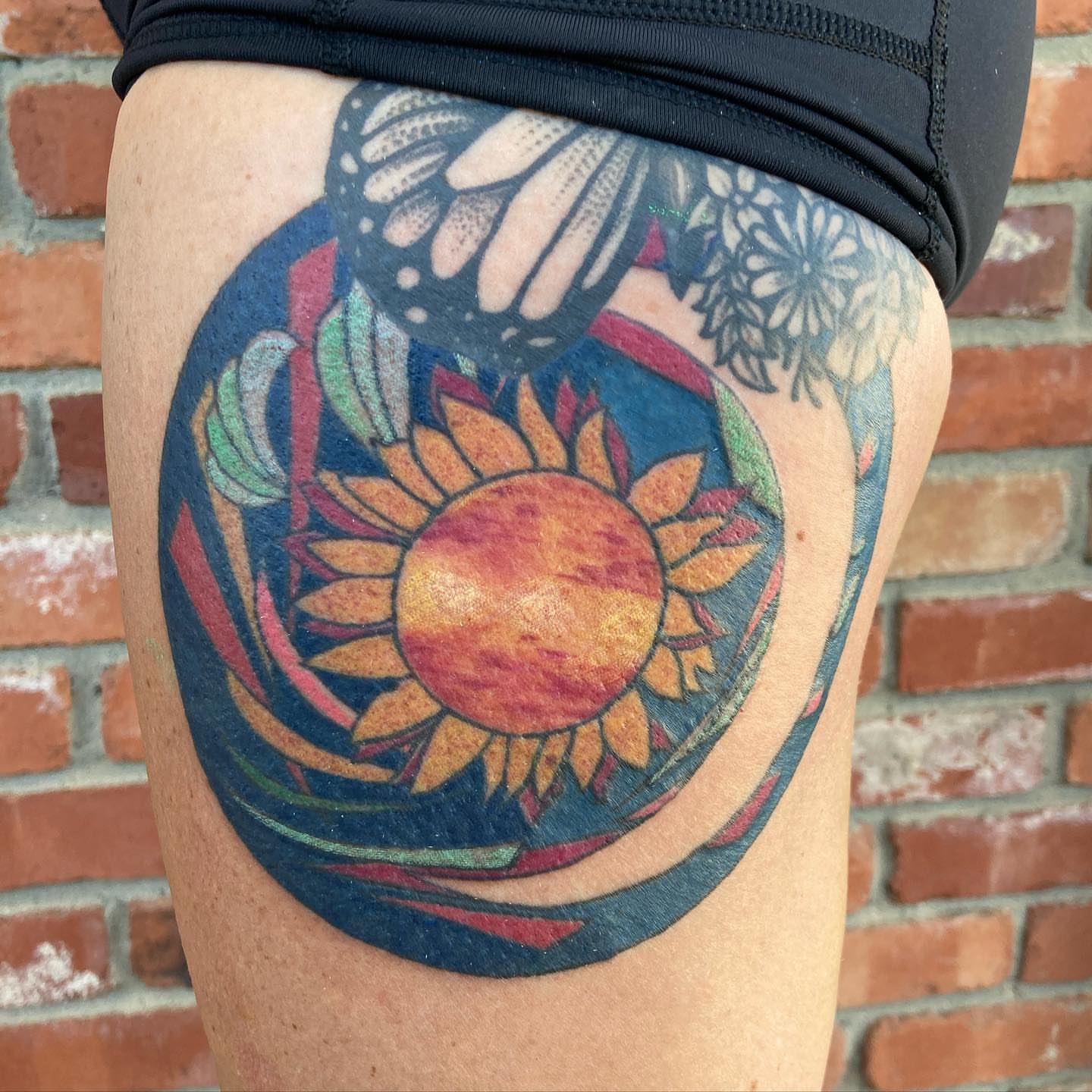 Sunflower new school tattoo on the thigh by Chuck House
