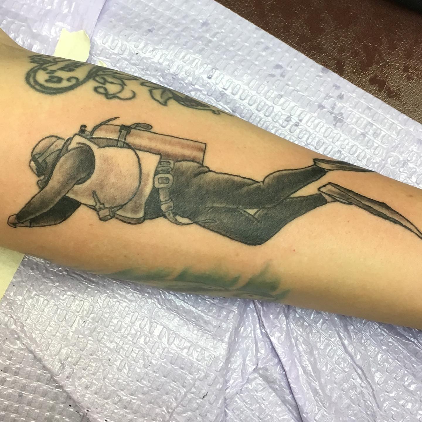 Diver black and grey tattoo on the forearm by Chuck House