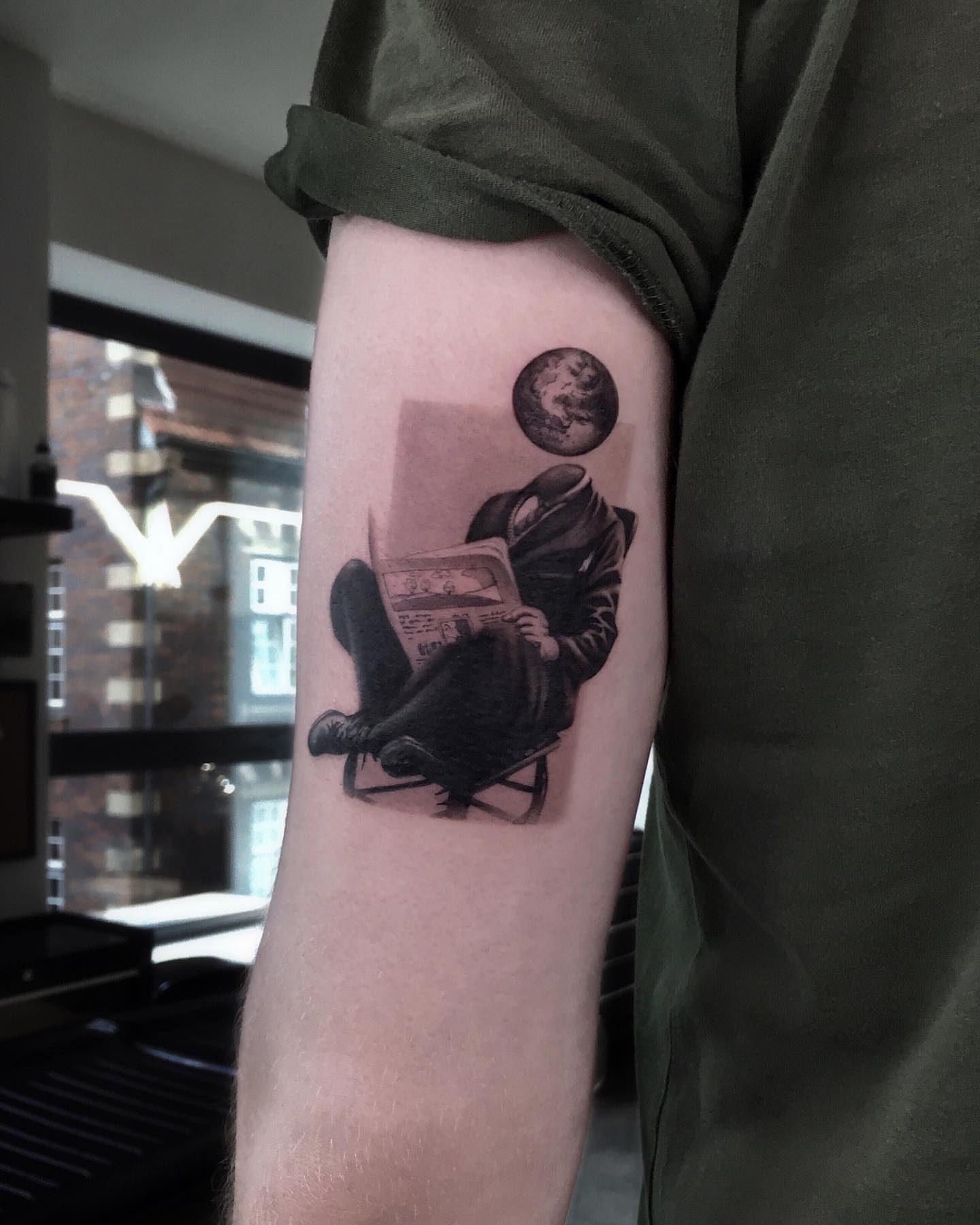 Man reading newspaper realism tattoo on the forearm by Oleksandr Moroz