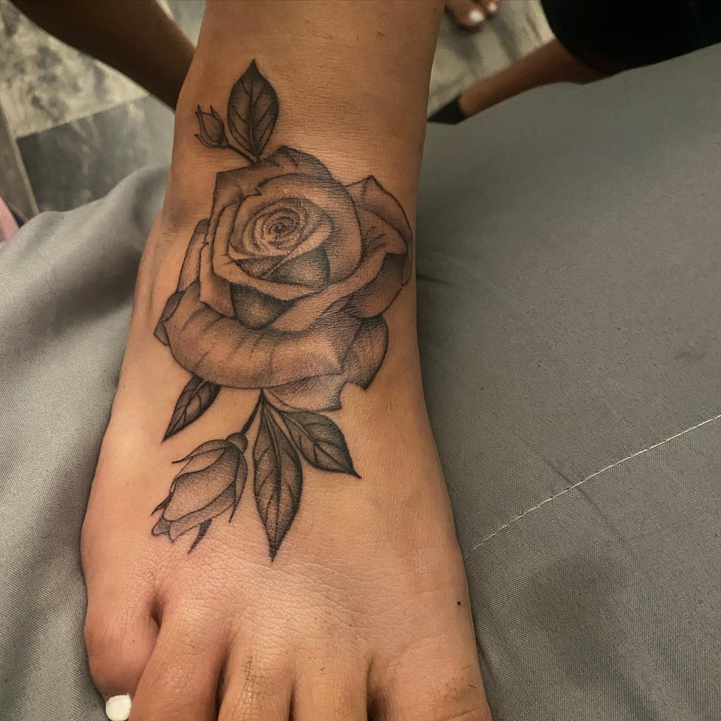 Rose black and grey tattoo on the foot by Cesar Nava