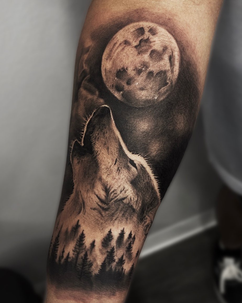 Wolf howling at moon realism tattoo on the forearm by Madison Ast Tattoo