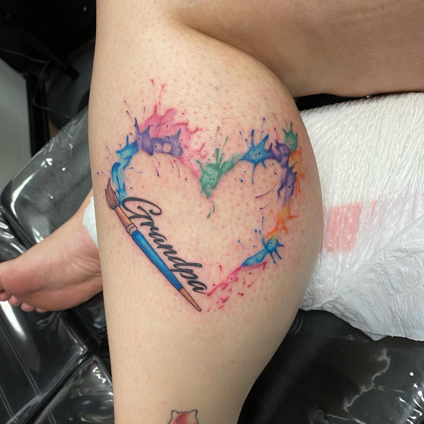 Heart with paint splashes watercolor tattoo on the thigh by Valen Laska