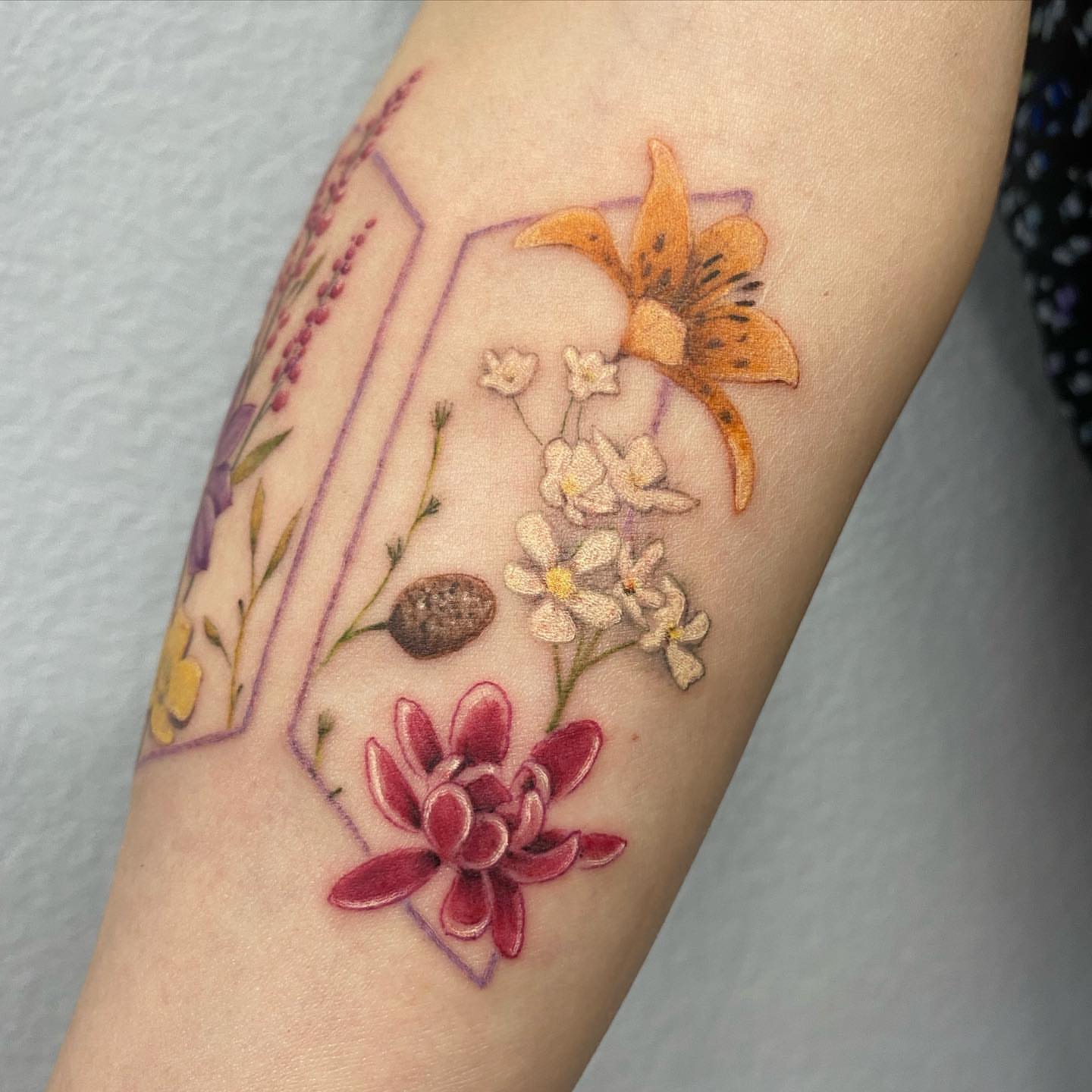 Floral arrangement watercolor tattoo on the forearm by Madison Ast Tattoo