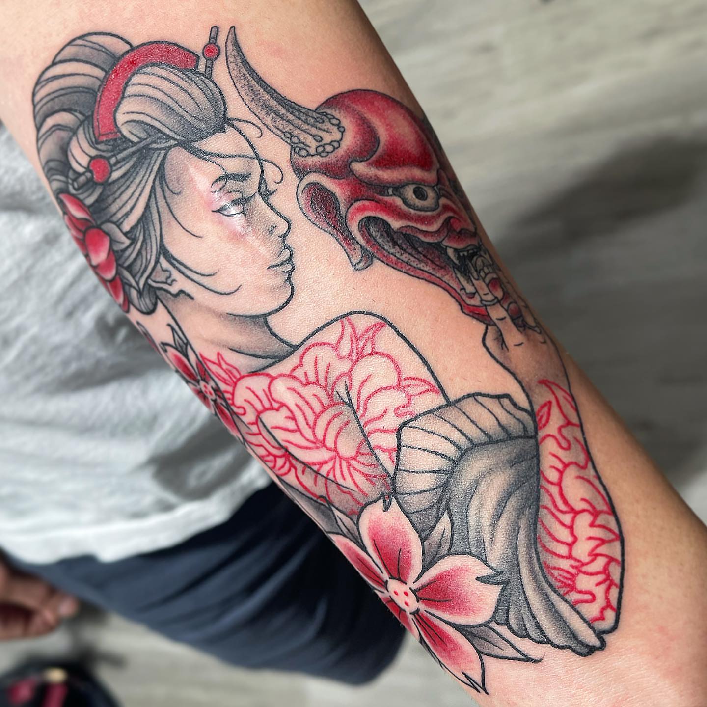 Geisha and mask American traditional tattoo on the forearm by Zack Havoc