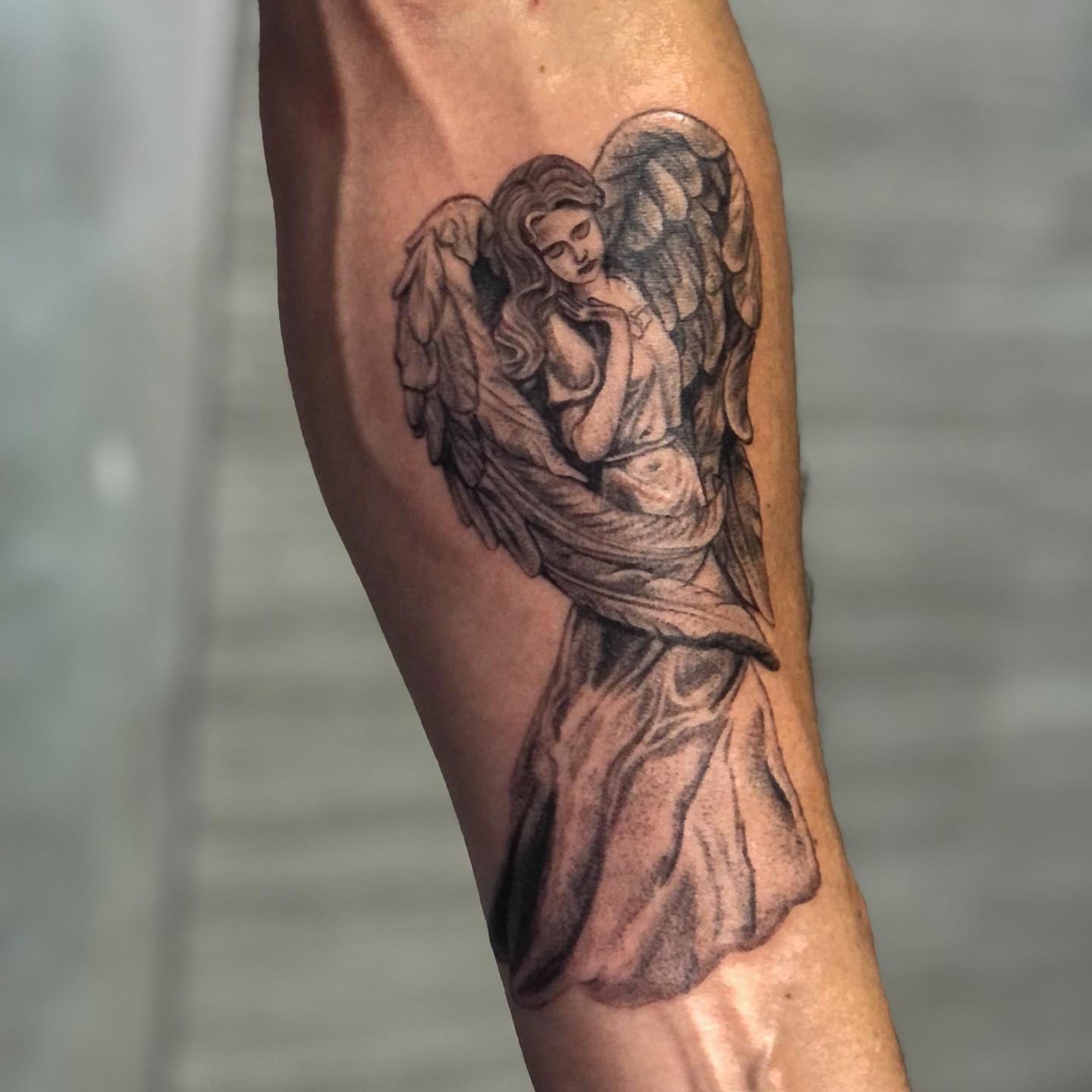 Angel black and grey tattoo on the forearm by NYC