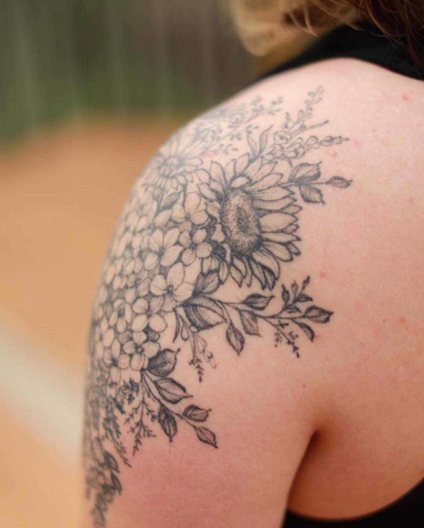 Sunflower and hydrangea black and grey tattoo on the shoulder by Sarah Spread