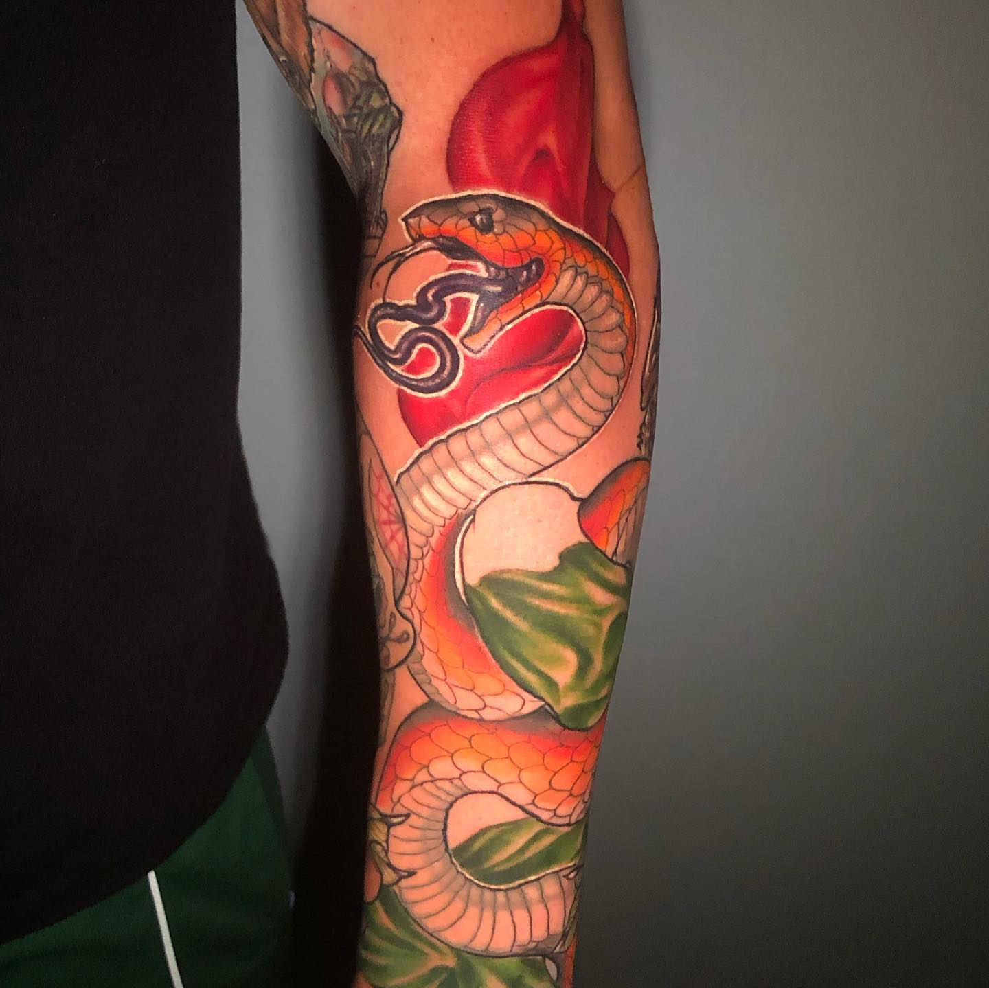 Snake and heart American traditional tattoo on the forearm by Josh Green