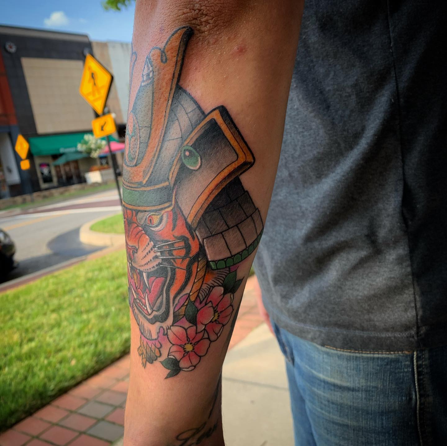 Tiger mask with flowers American traditional tattoo on the forearm by Brad Sterling
