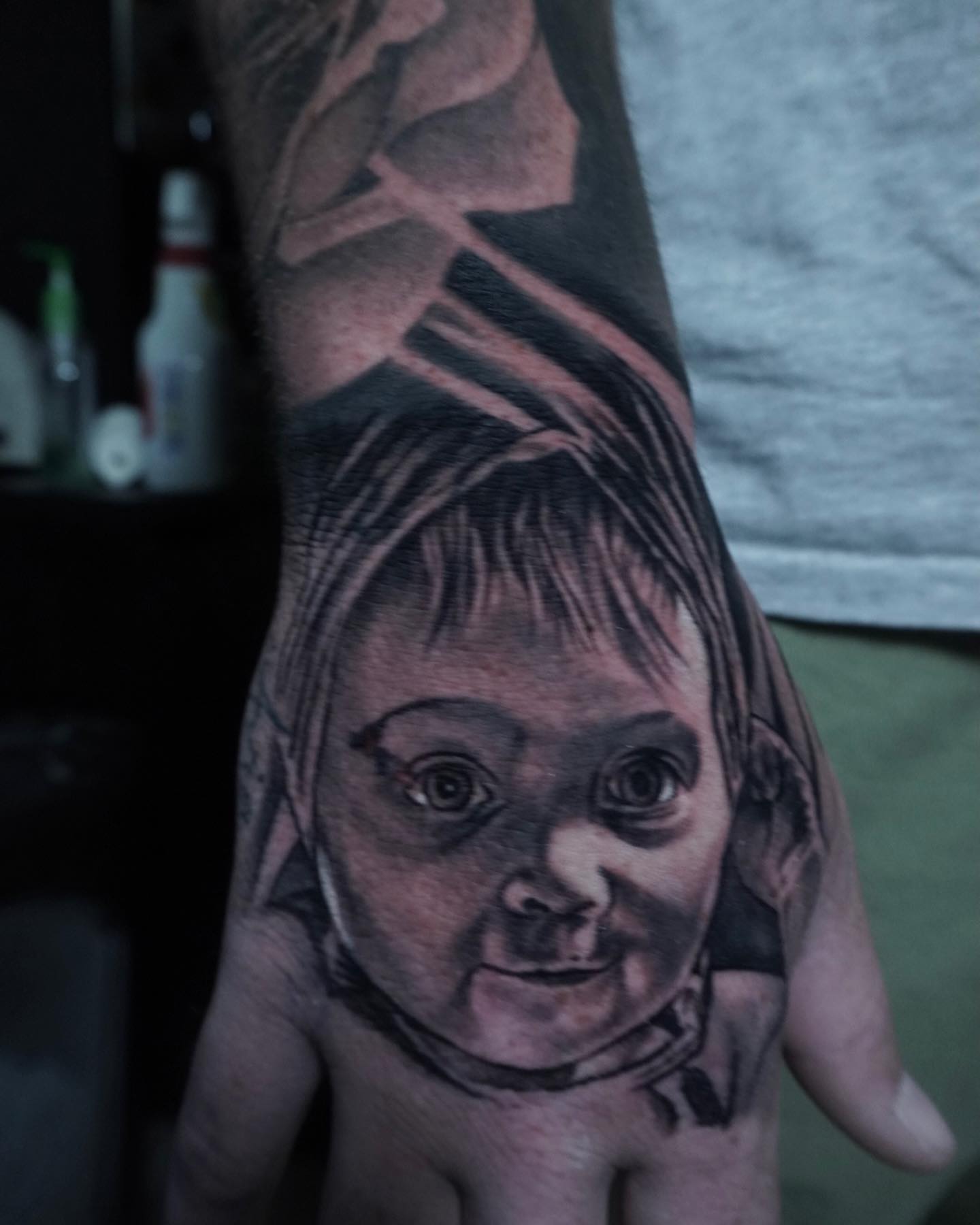 Child's face realism tattoo on the hand by Brian Cassidy
