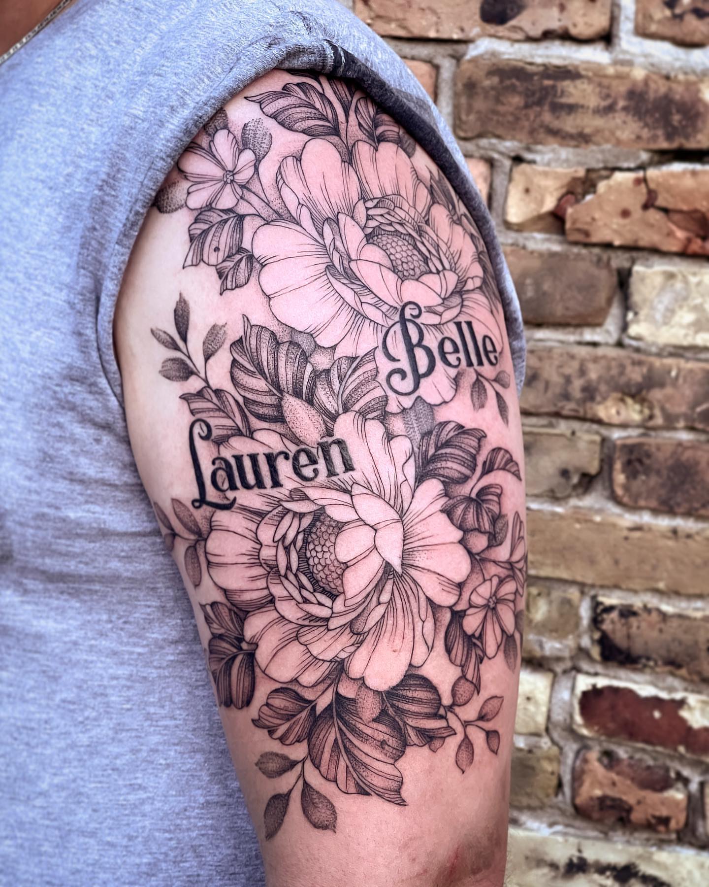 Floral arrangement black and grey tattoo on the shoulder by Michigan Tattoo Artist